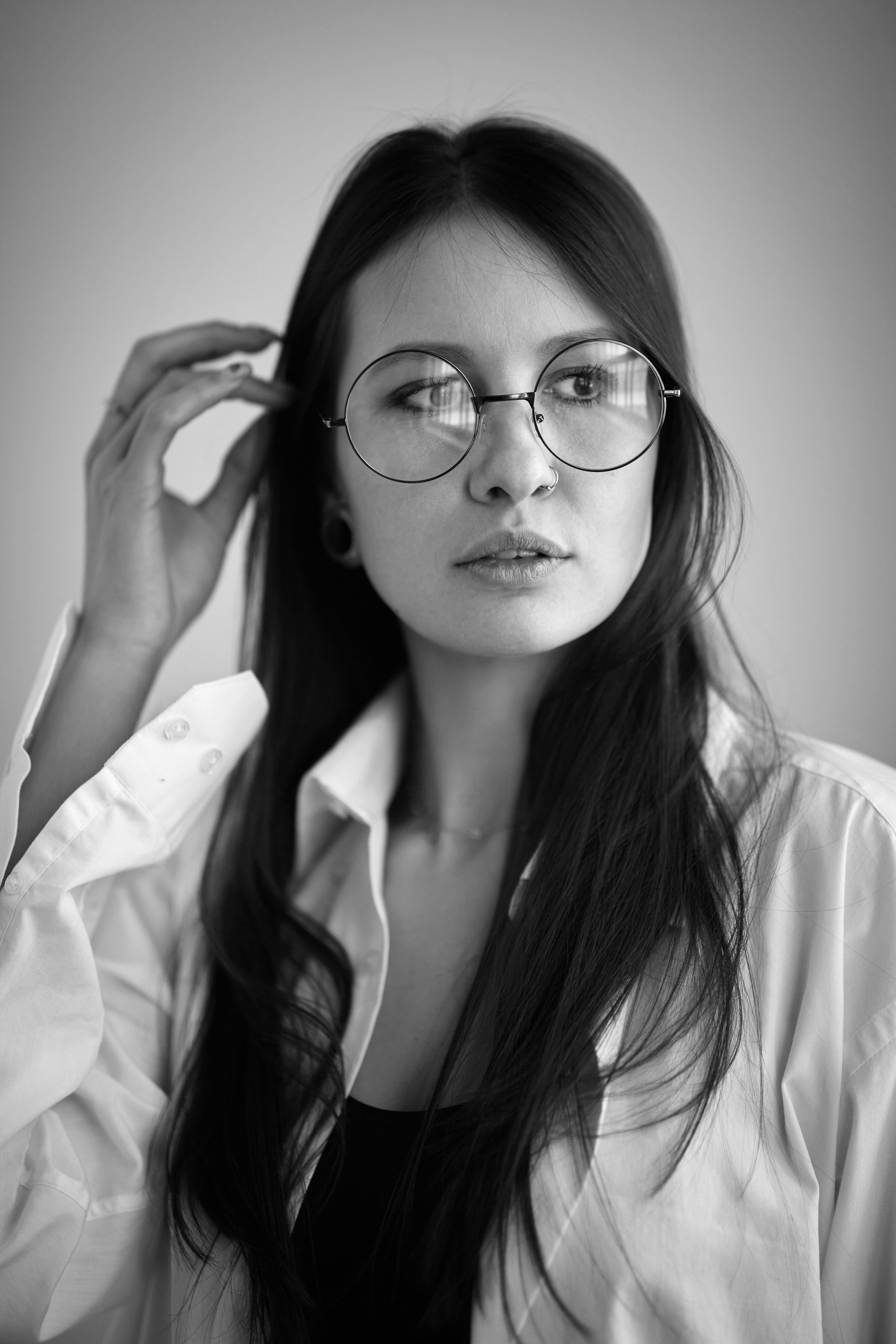 Темноволосая девушка на темном фоне в студии демонстрирует свои прелести.