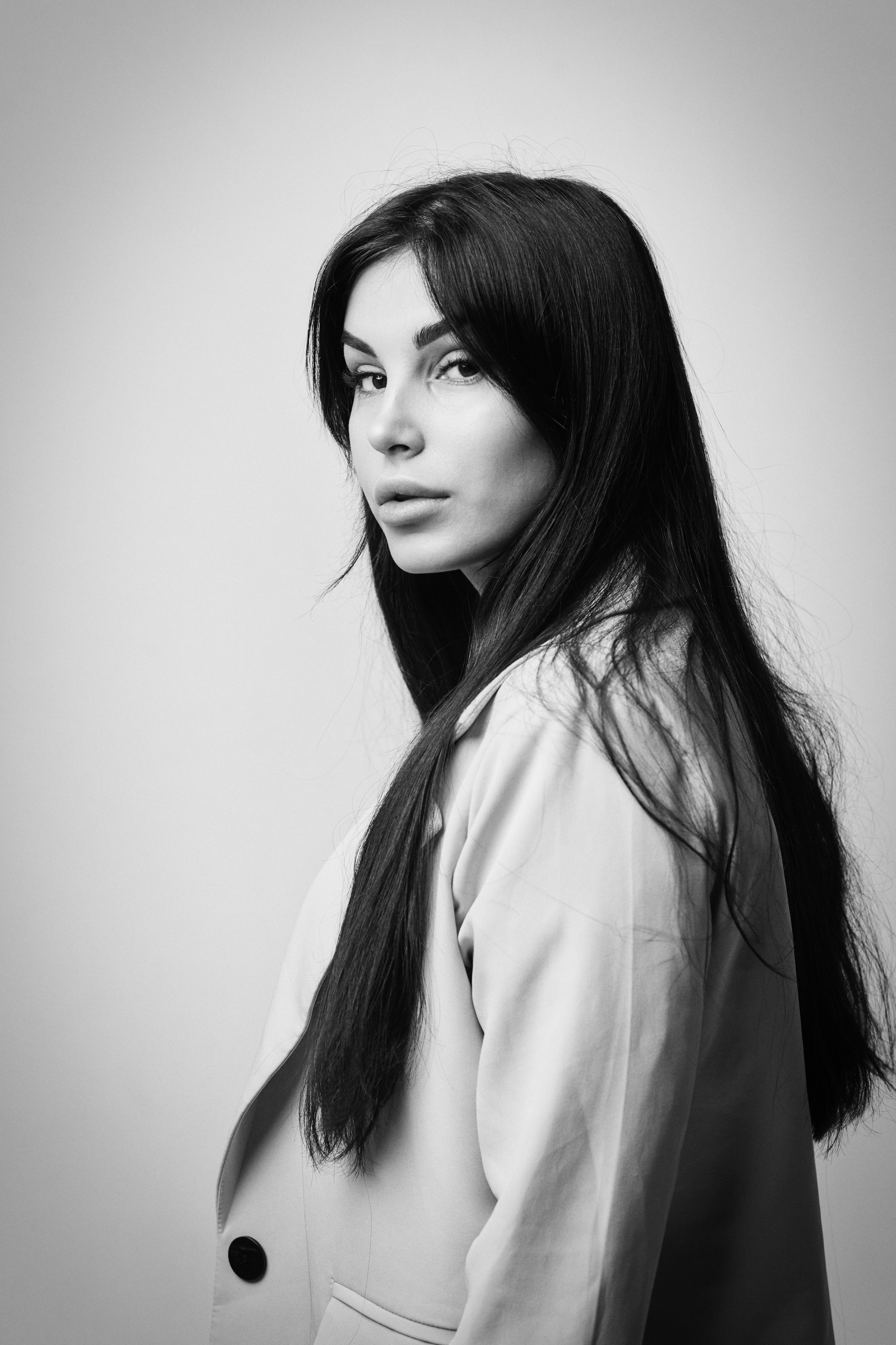 Темноволосая Карина в рубашке на светлом фоне