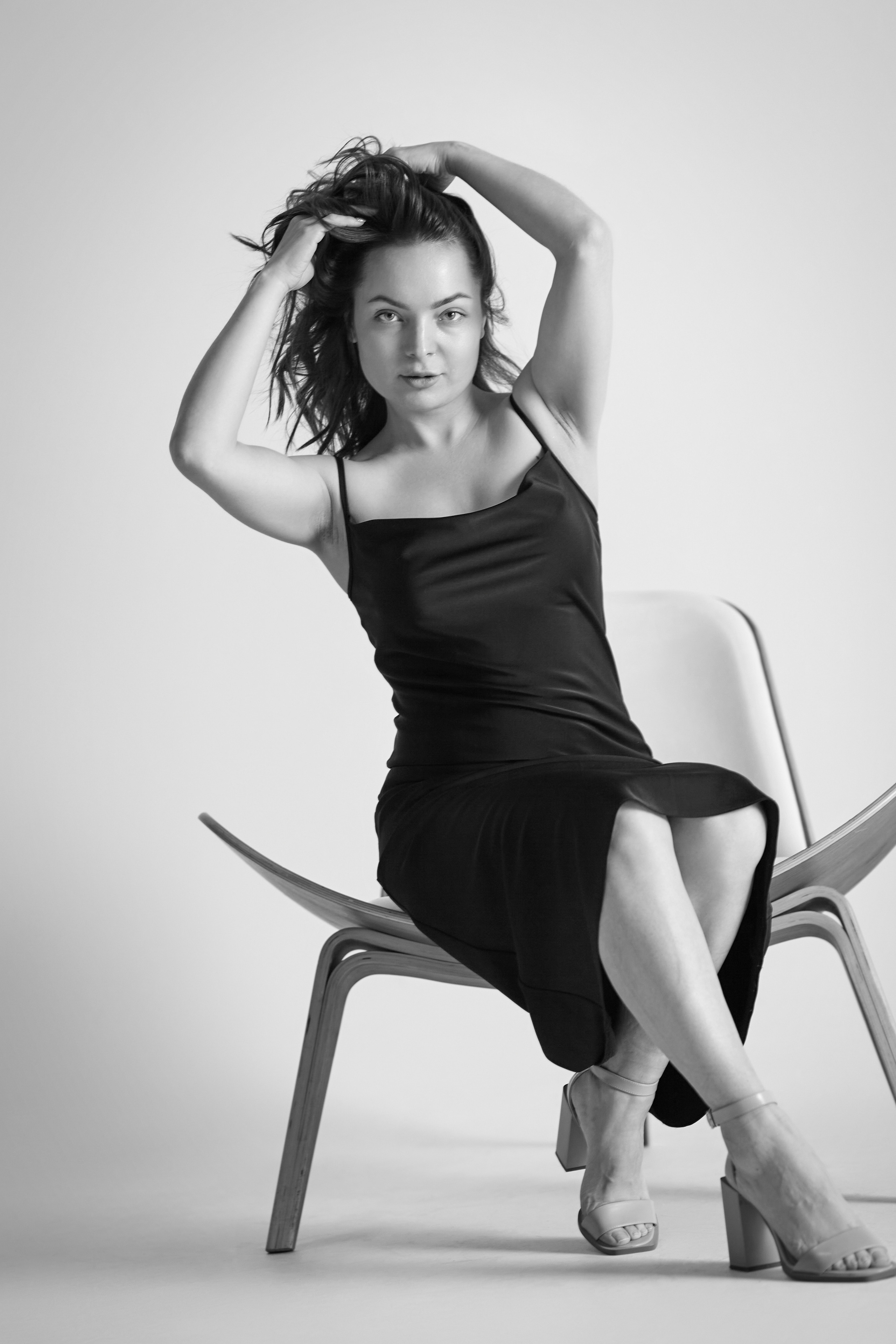 В рубашке стоит темноволосая модель Татьяна в студии на светлом фоне.