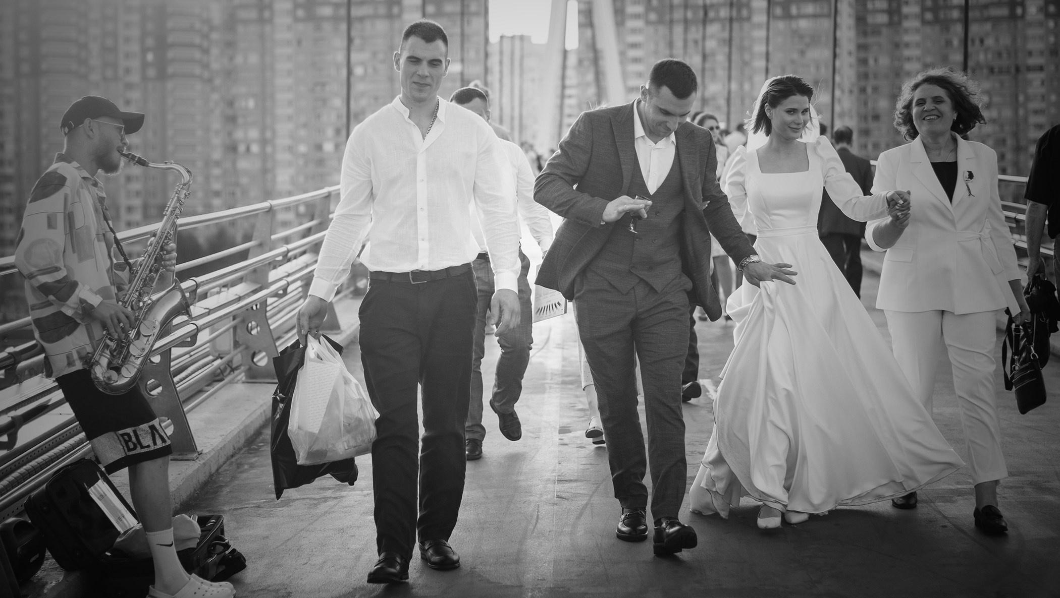 черно белая фотография где жених с невестой идут со своими друзьями 