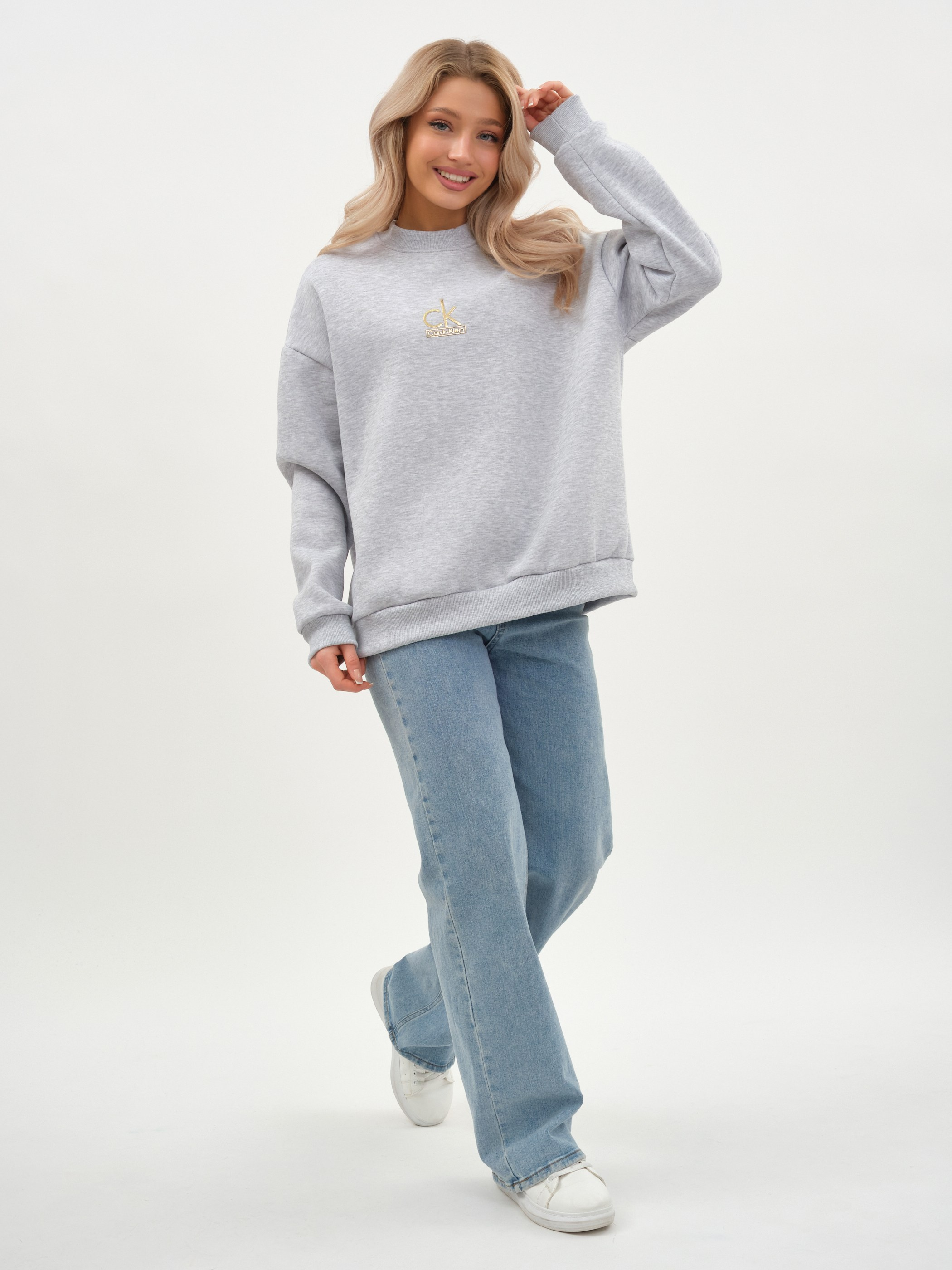Женщина в сером свитшоте и джинсах