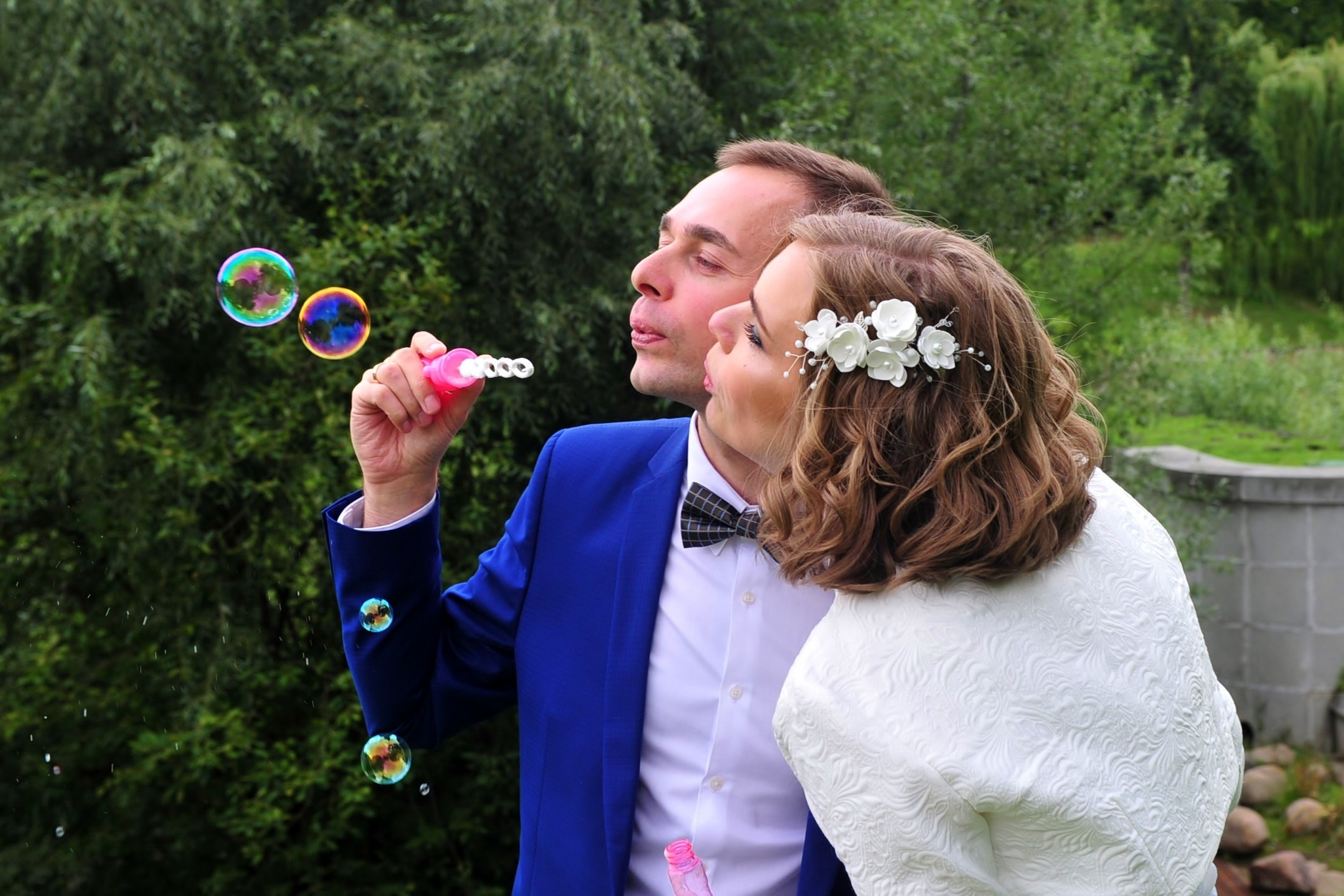 Свадьба в Царицыно хмурым прохладным летним днём, новобрачные с мыльными пузырями, жених выдувает мыльные пузыри