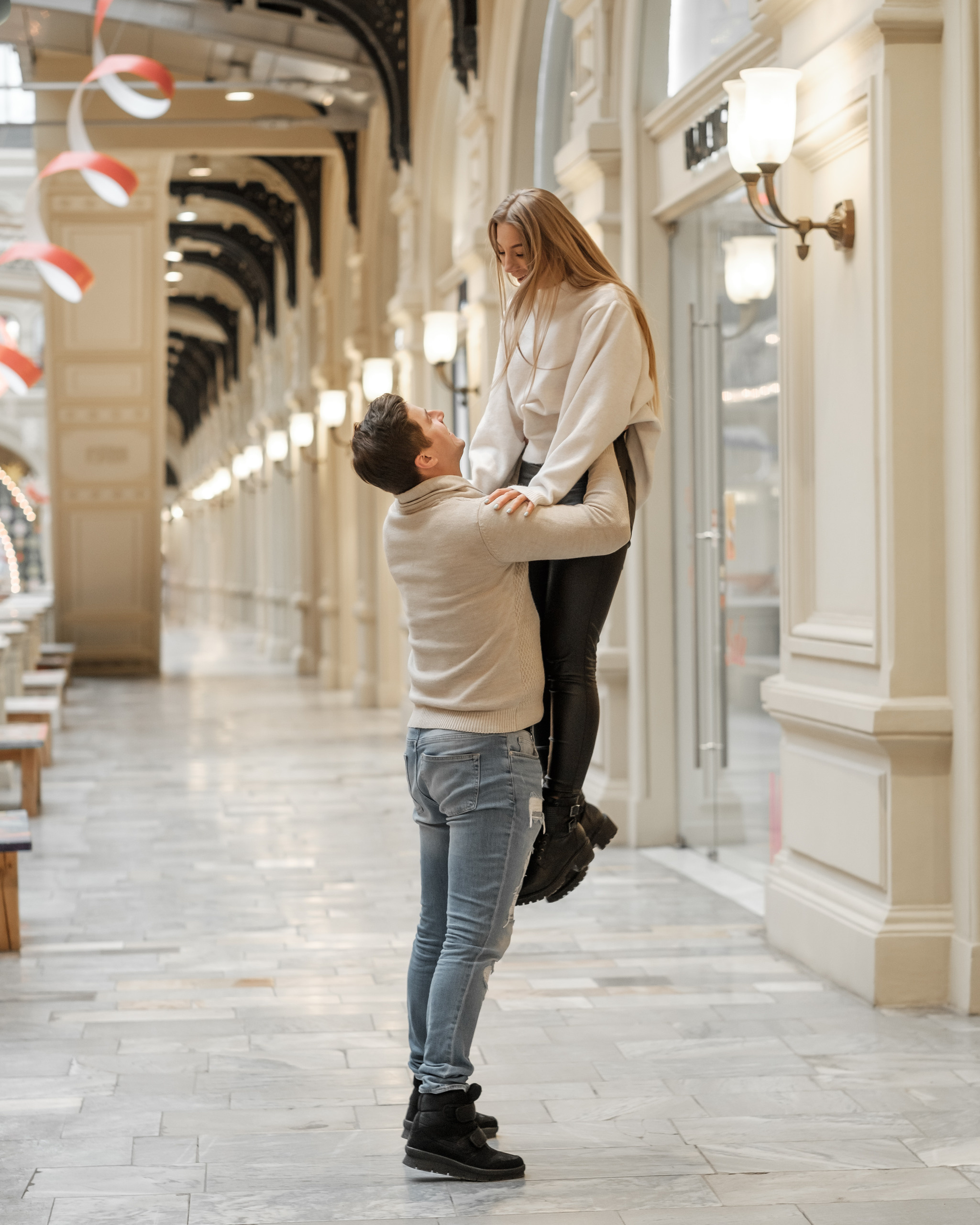 Парень и девушка в белых свитерах в ГУМе Москва