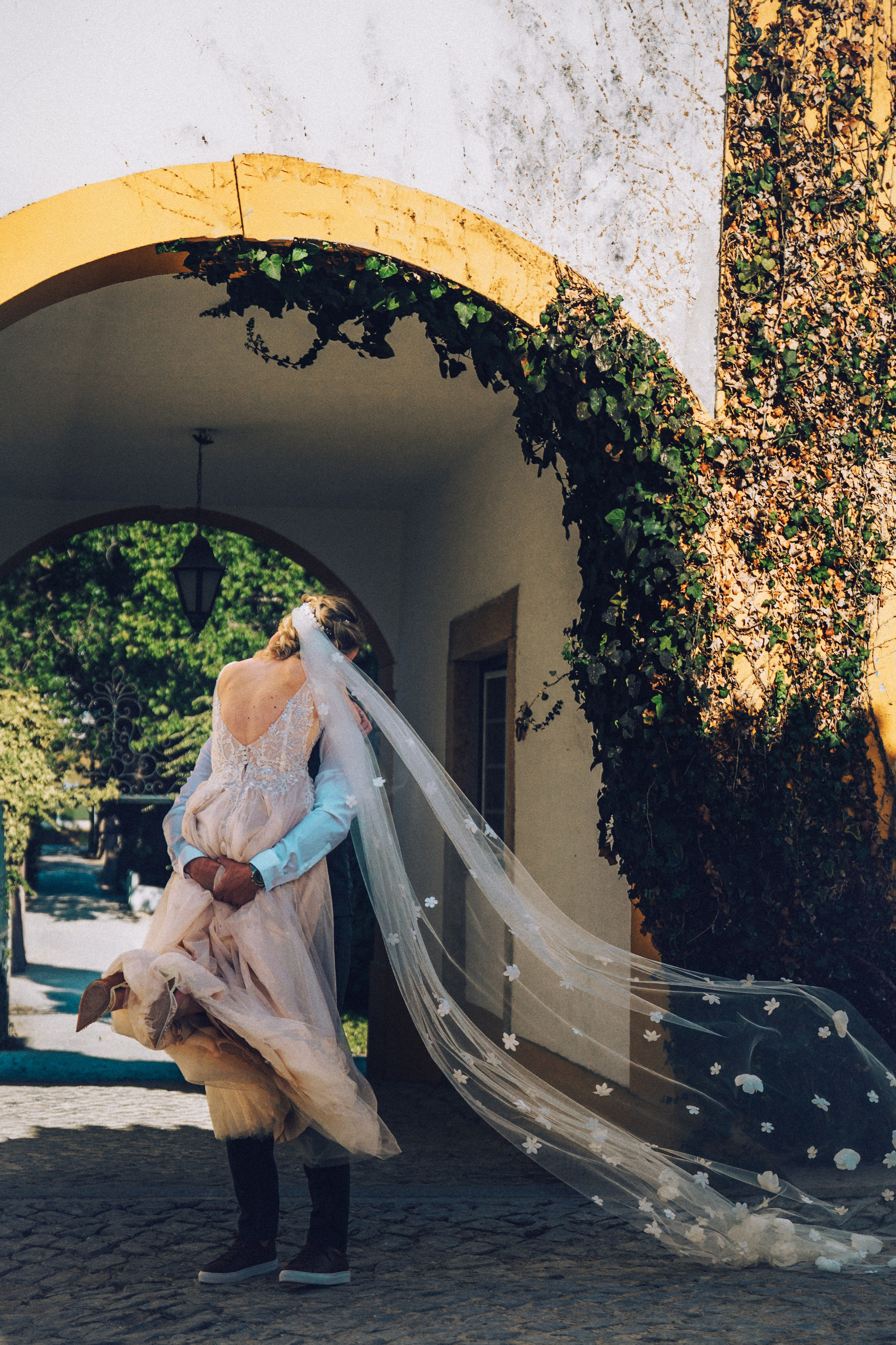 Влюбленная  пара жених и невеста целуется и обнимаются на фоне старинных улочек Португалии