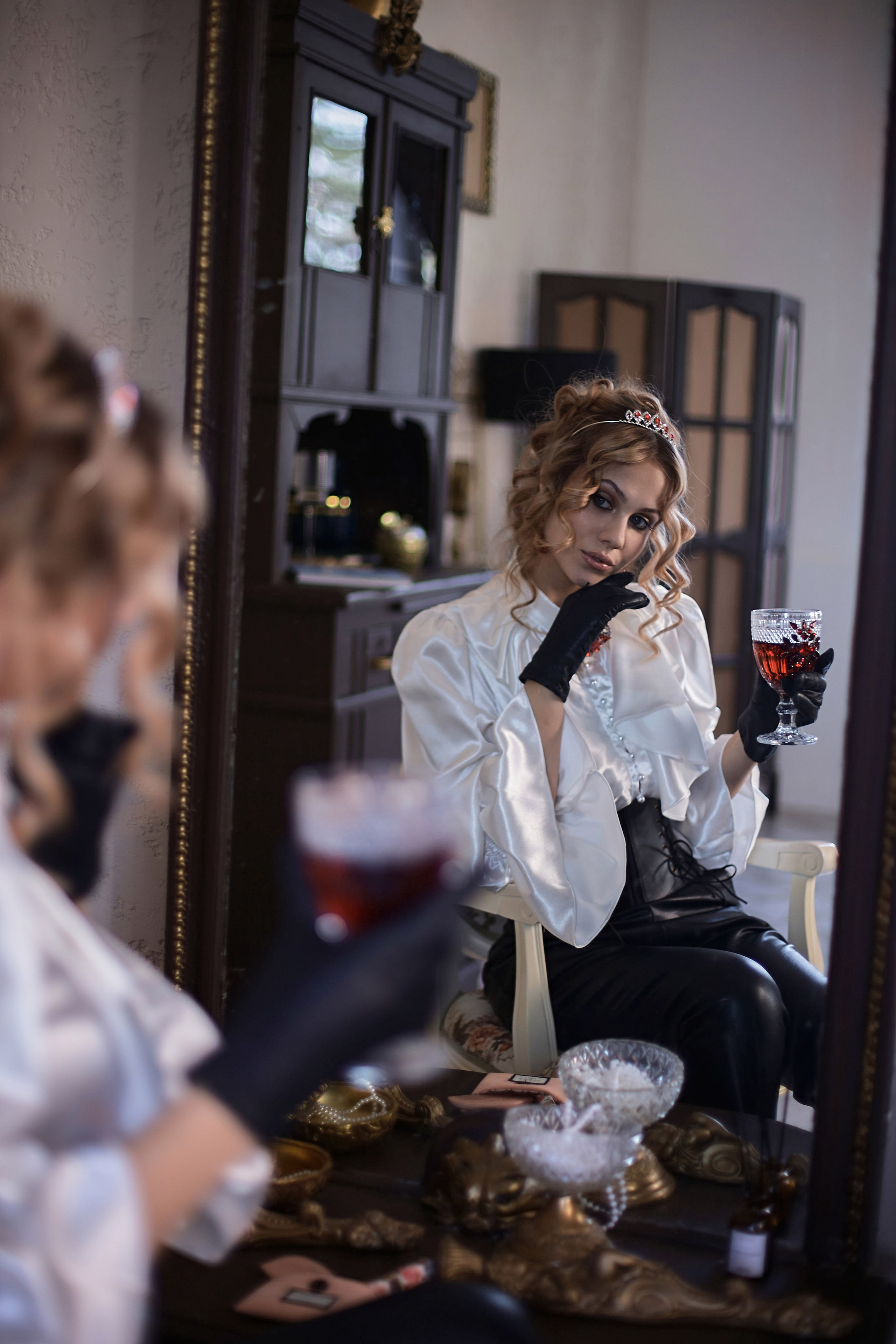 Отражение в зеркале девушки в винтажном образе с бокалом вина