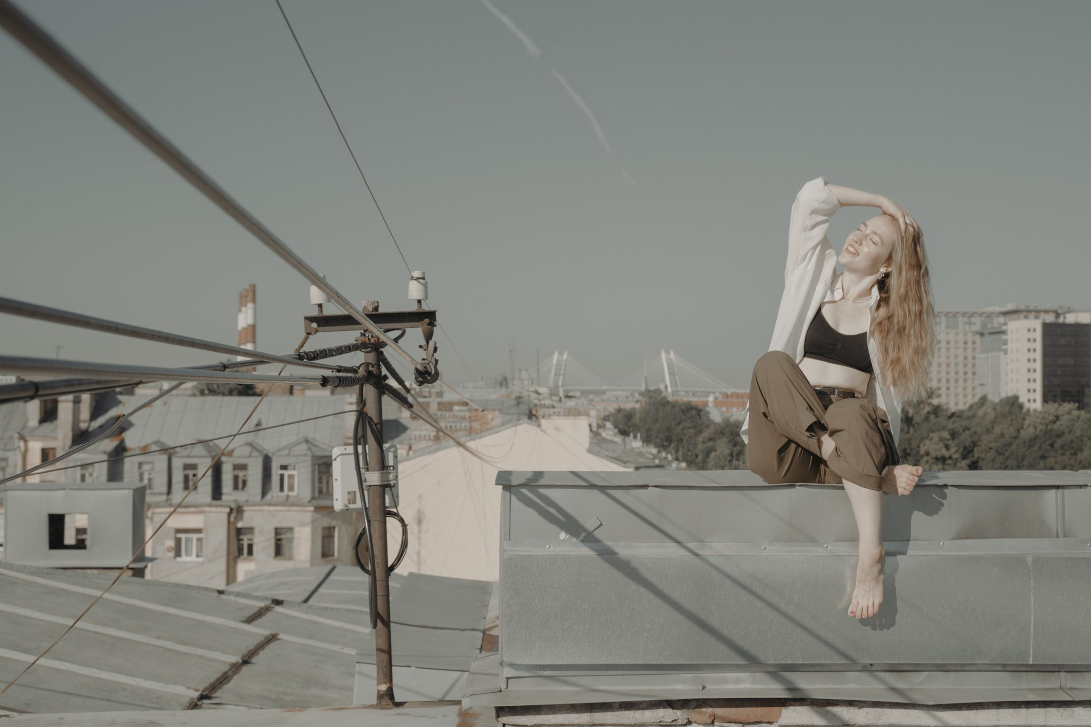 Общий кадр девушки с проводами на крыше в Питере