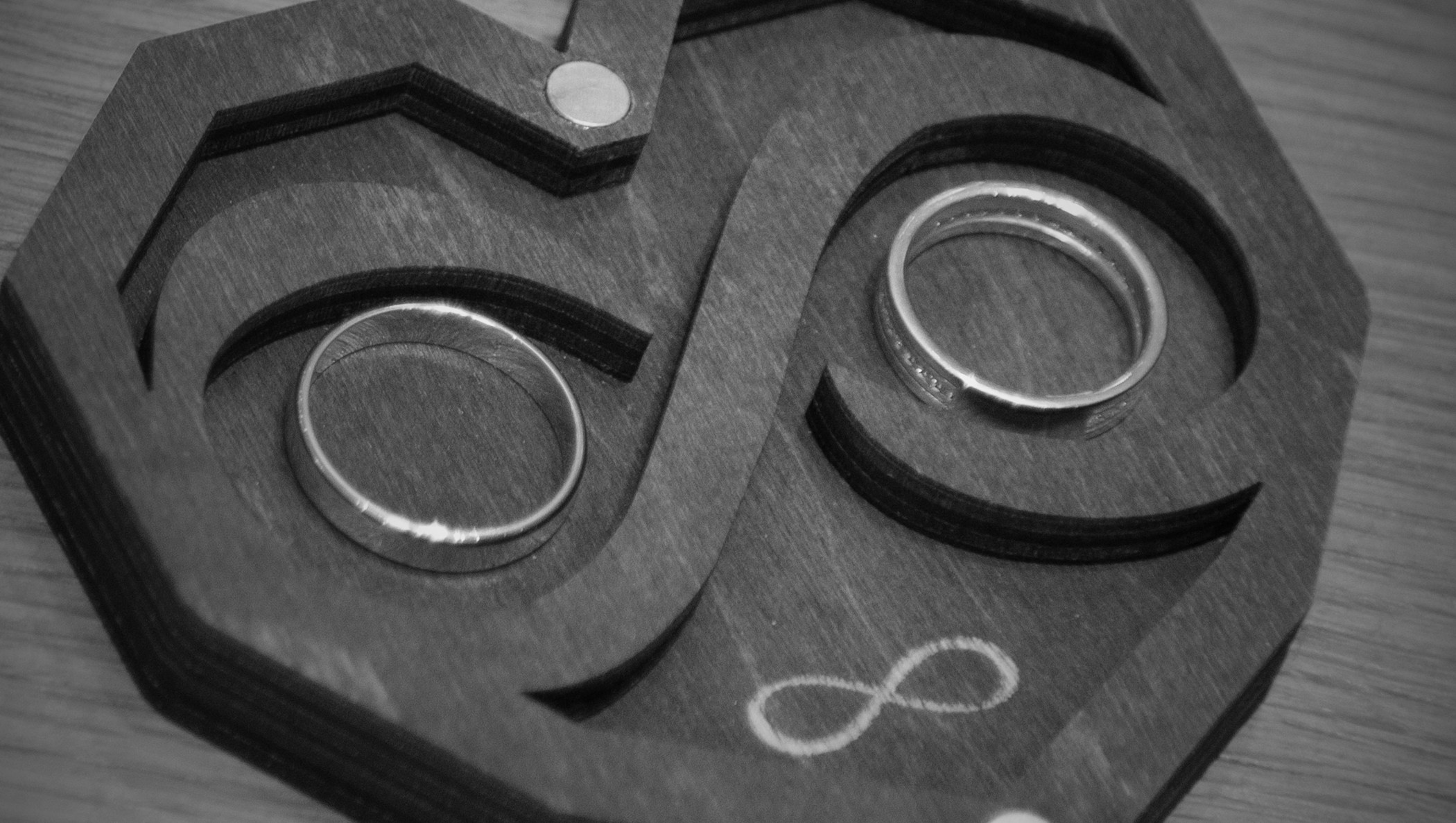 черно белое фото обручальных колец на темном фоне 