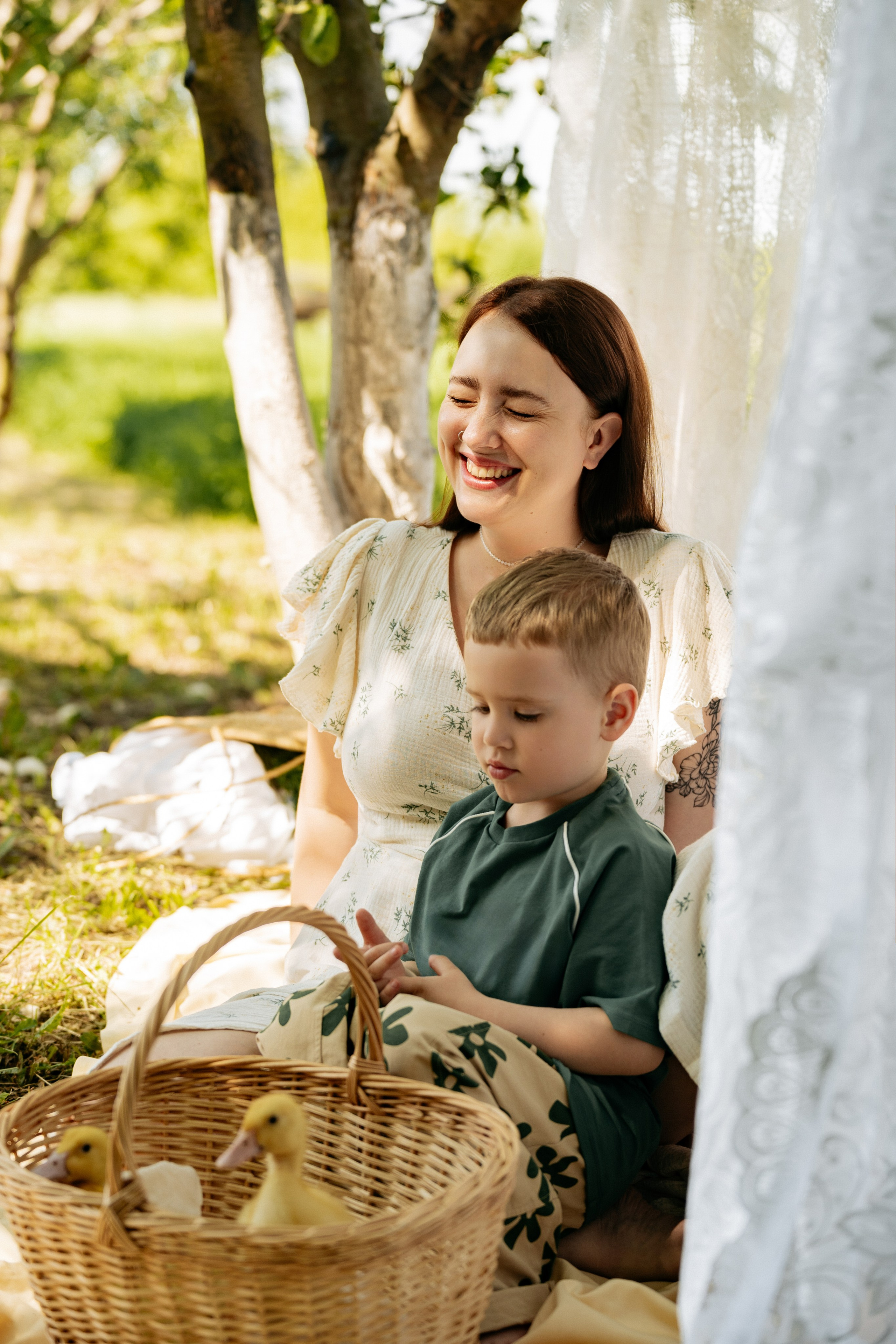 Теплые объятия мамы и ребенка рядом с корзинкой, где сидят пушистые утята, фотограф Кучугуры