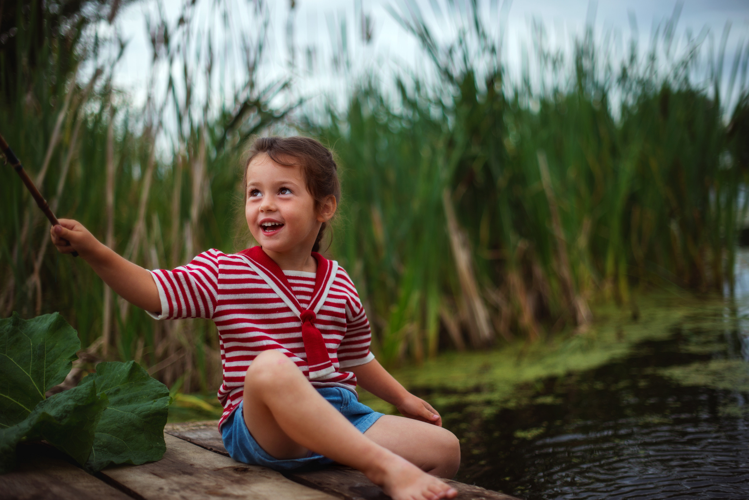 девочка рыбачка на берегу озера в матроске