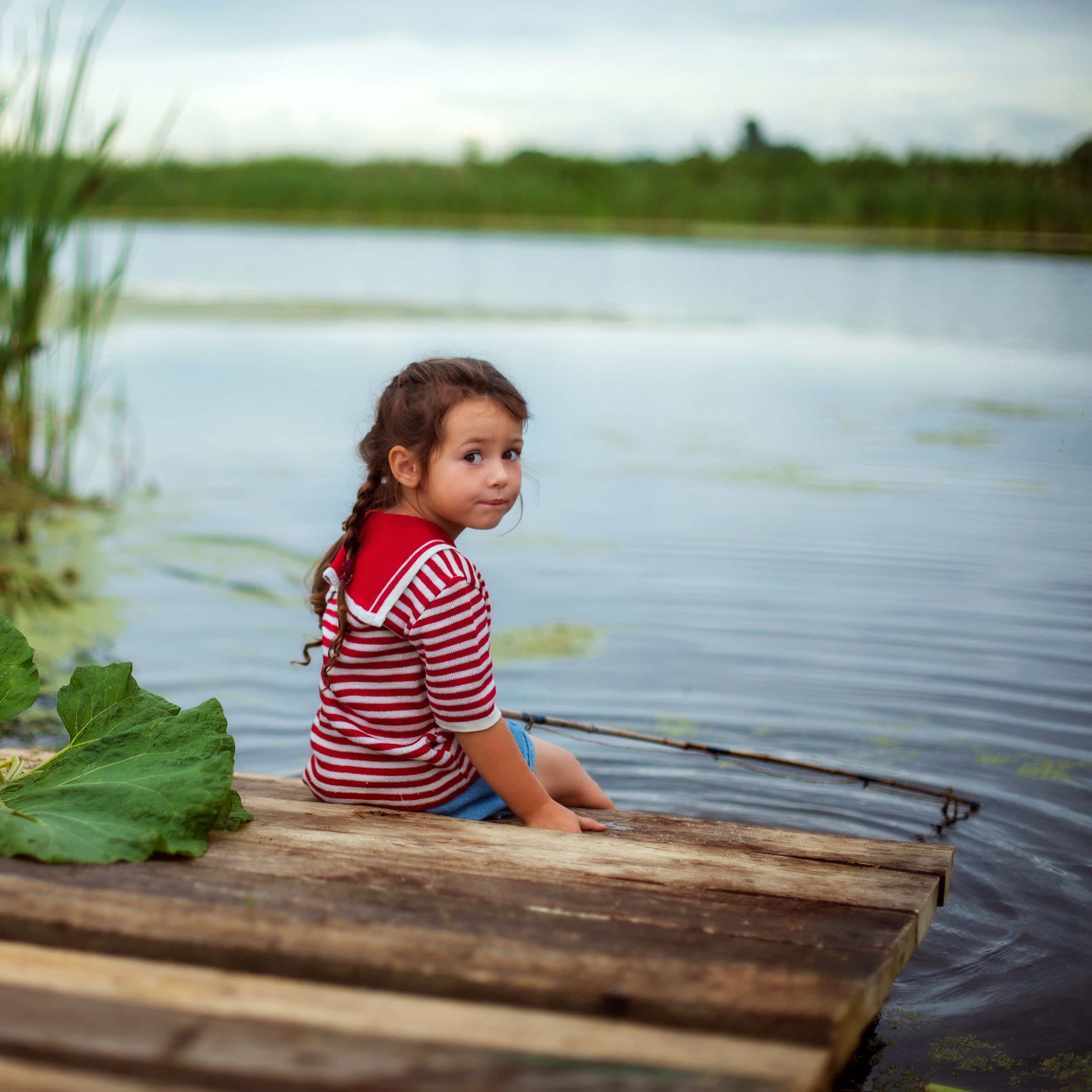 девочка рыбачка на берегу озера в матроске