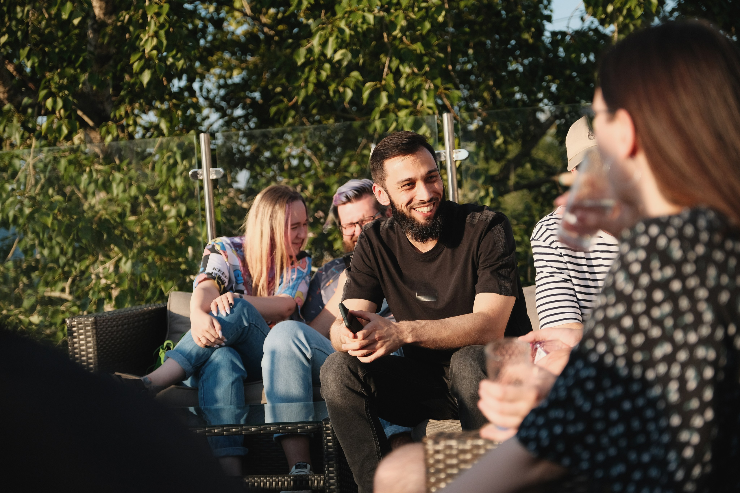 Парень с бородой болтает на вечеринке.