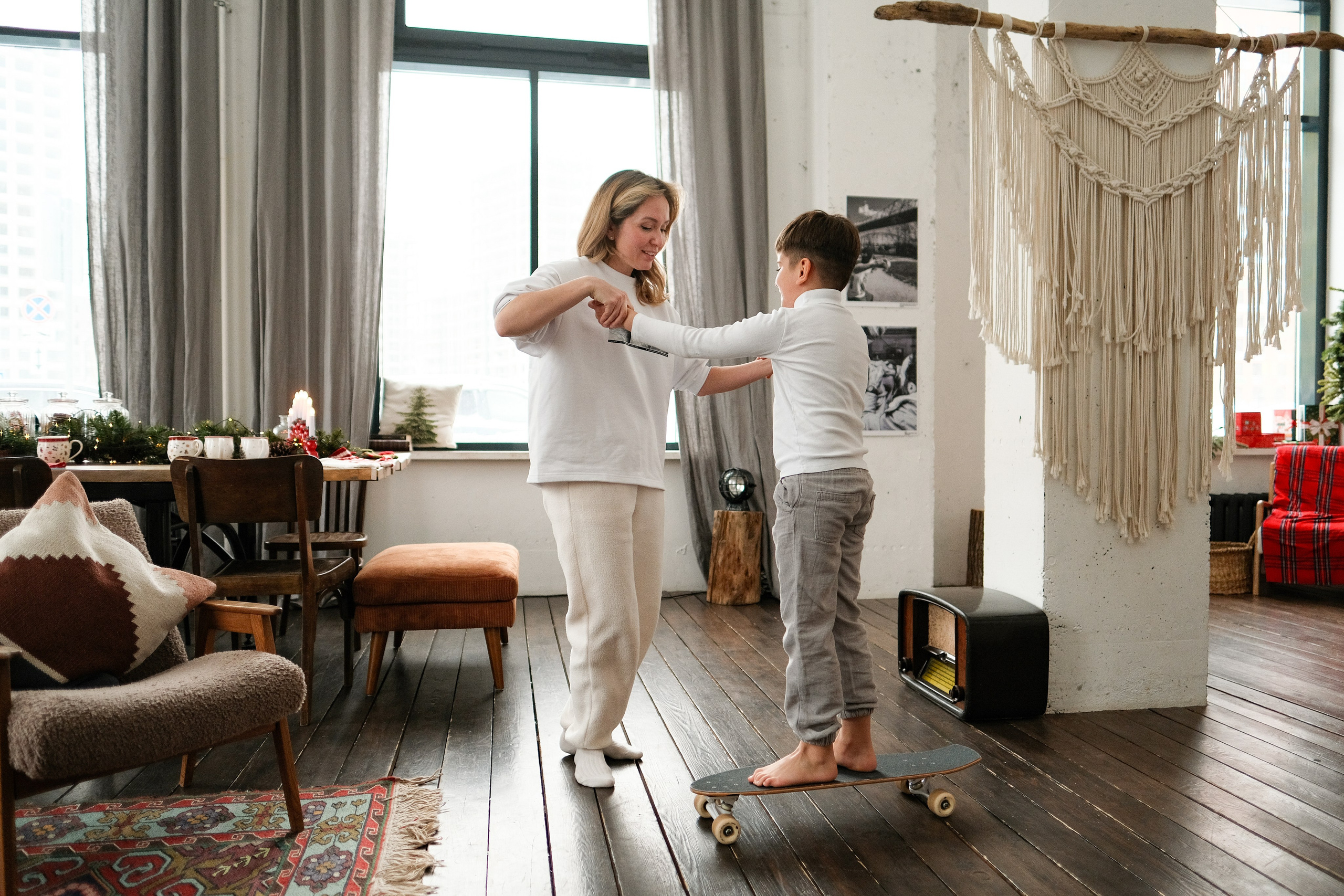 Мальчик обучает маму езде на скейте.