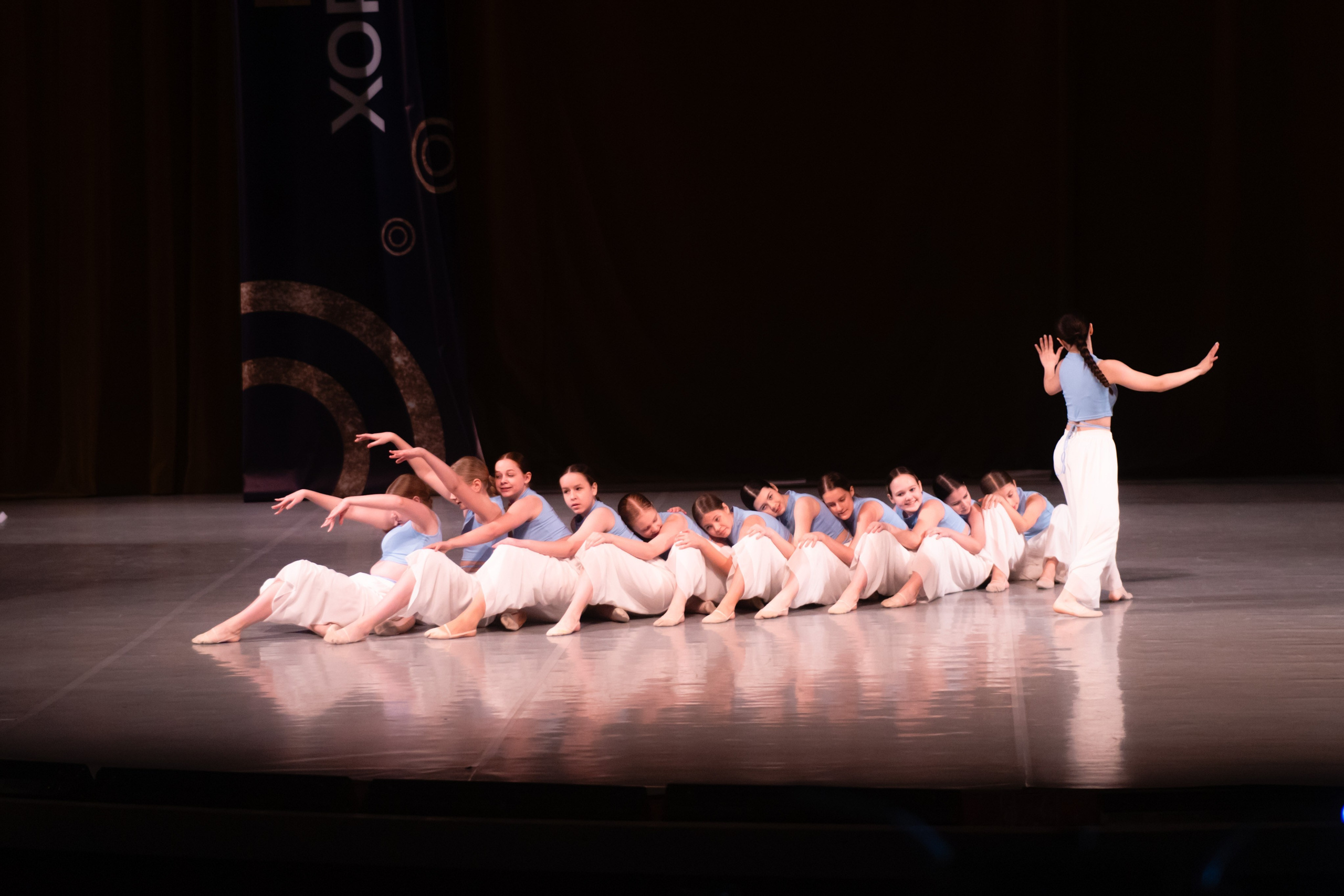 Сцена отеля «Санкт-Петербург» с группой танцоров на фоне световой панели.