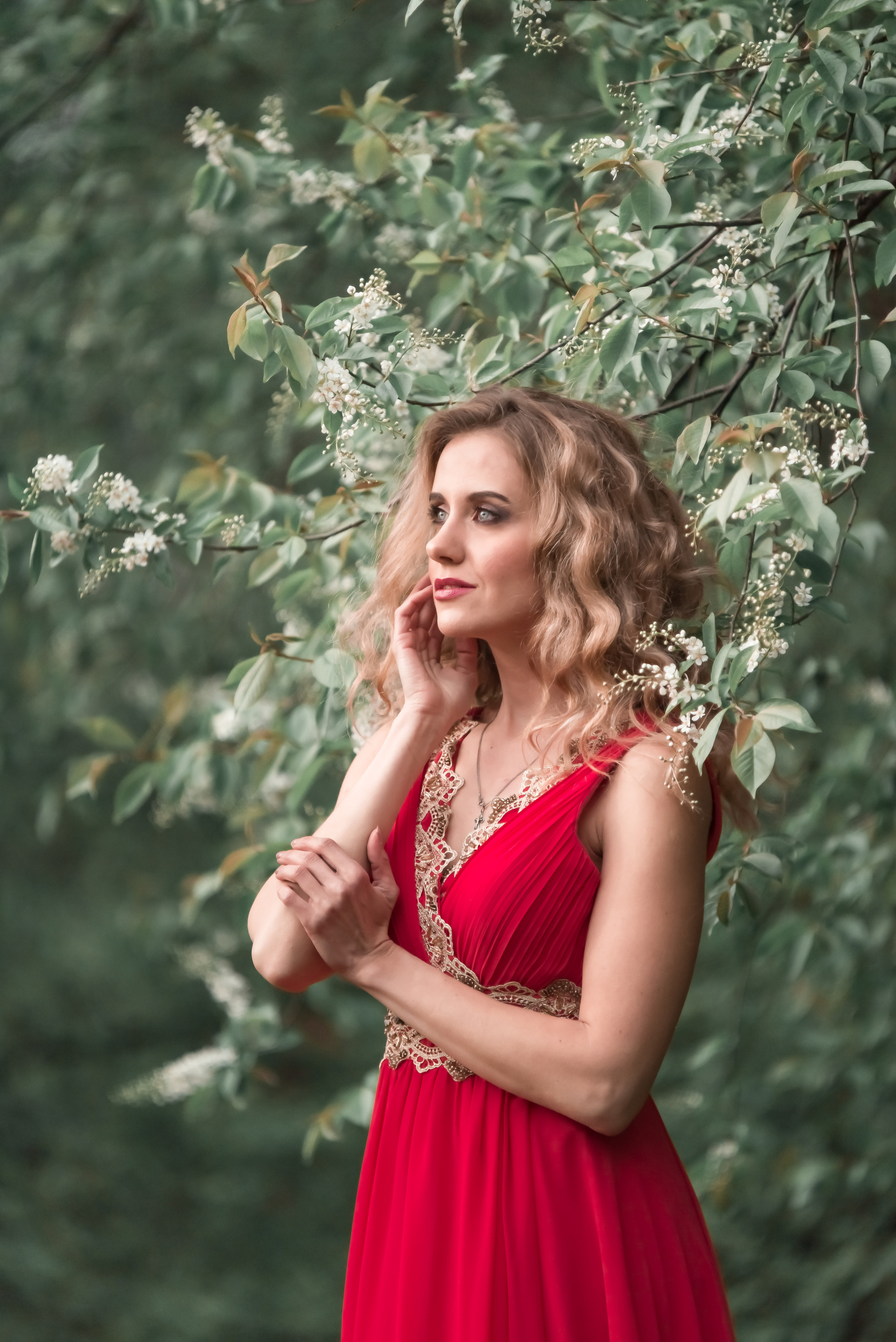 Девушка в летящем шифоном платье кораллового цвета в лесу