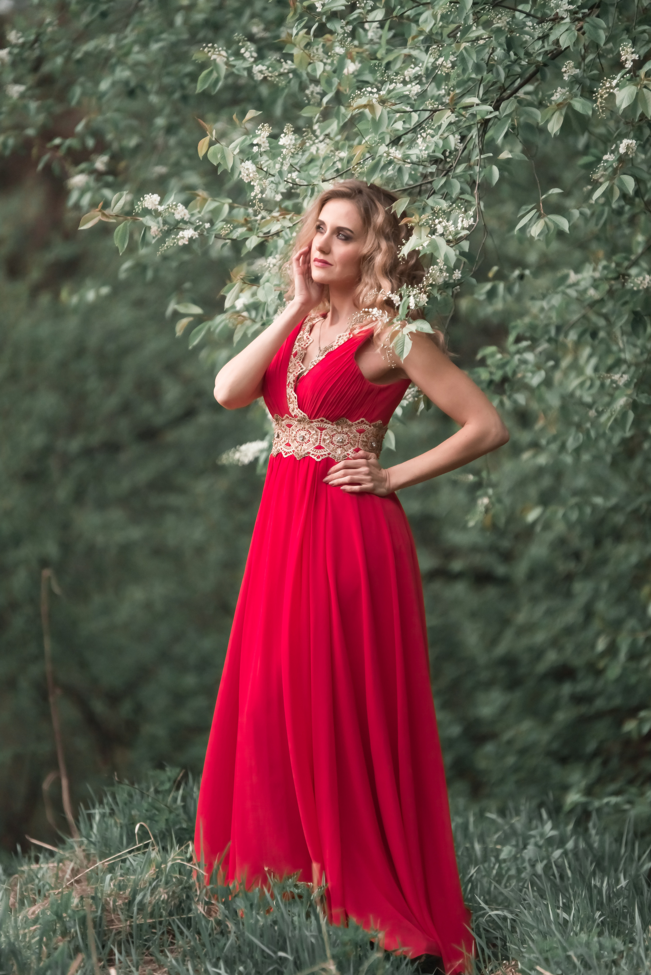 Девушка в летящем шифоном платье кораллового цвета в лесу