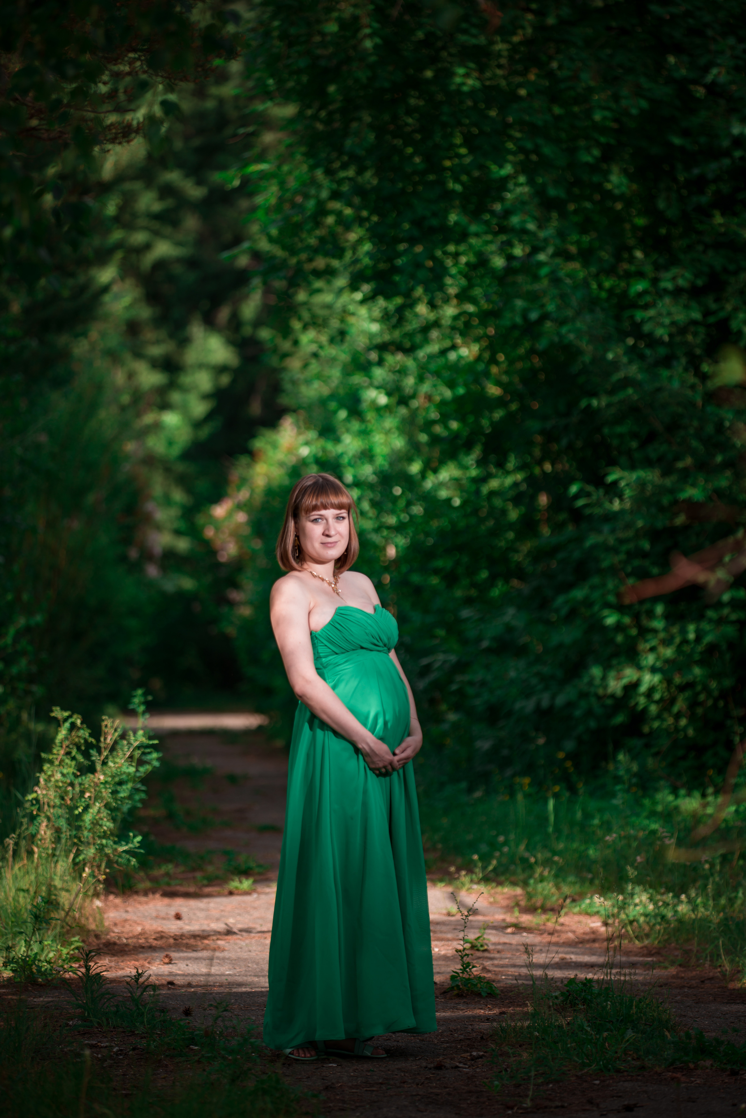 Девушка в зеленом шифоновом платье в лесу на фотопрогулке