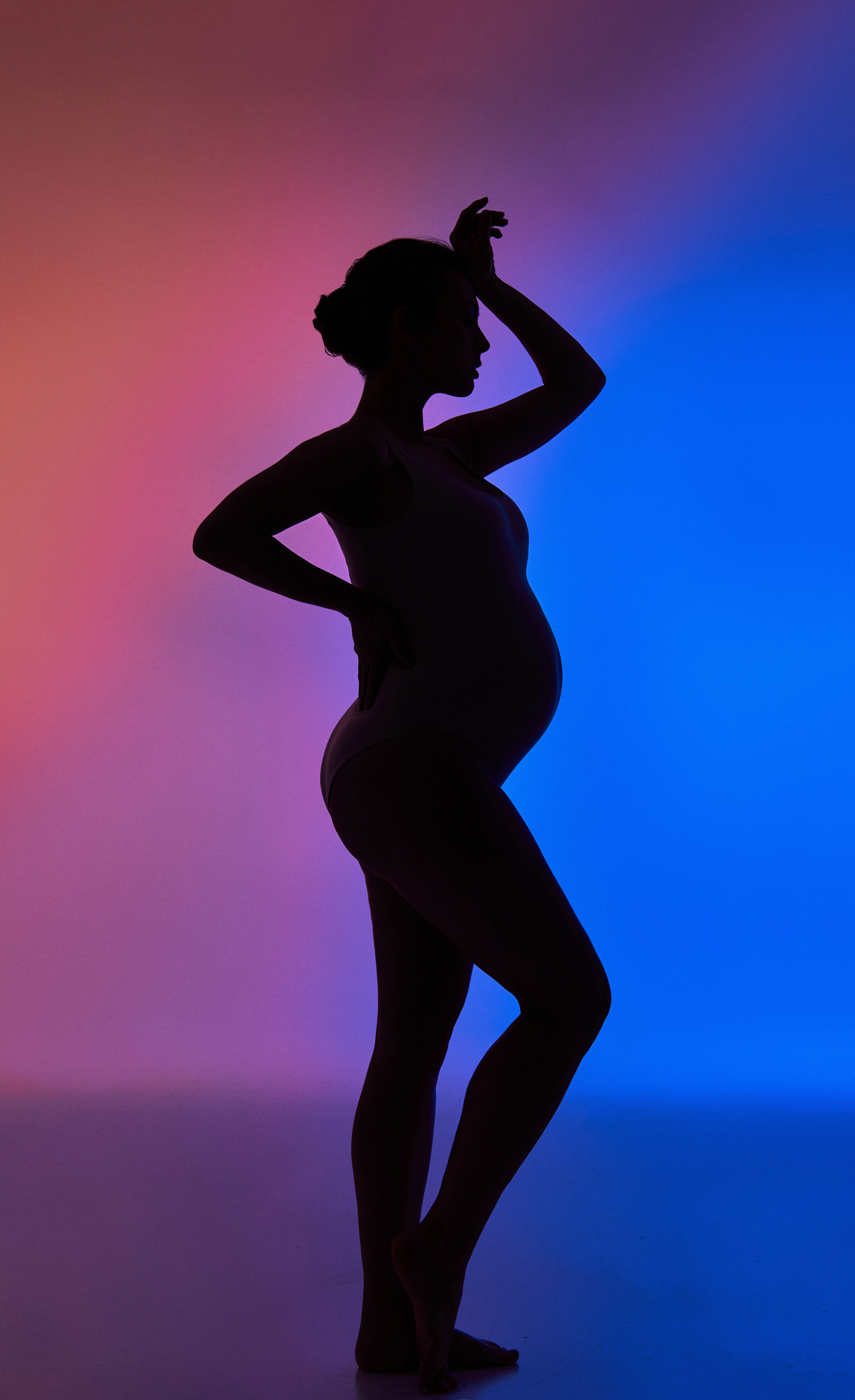 силуэт беременной девушки на цветном фоне в фотостудии Домодедово