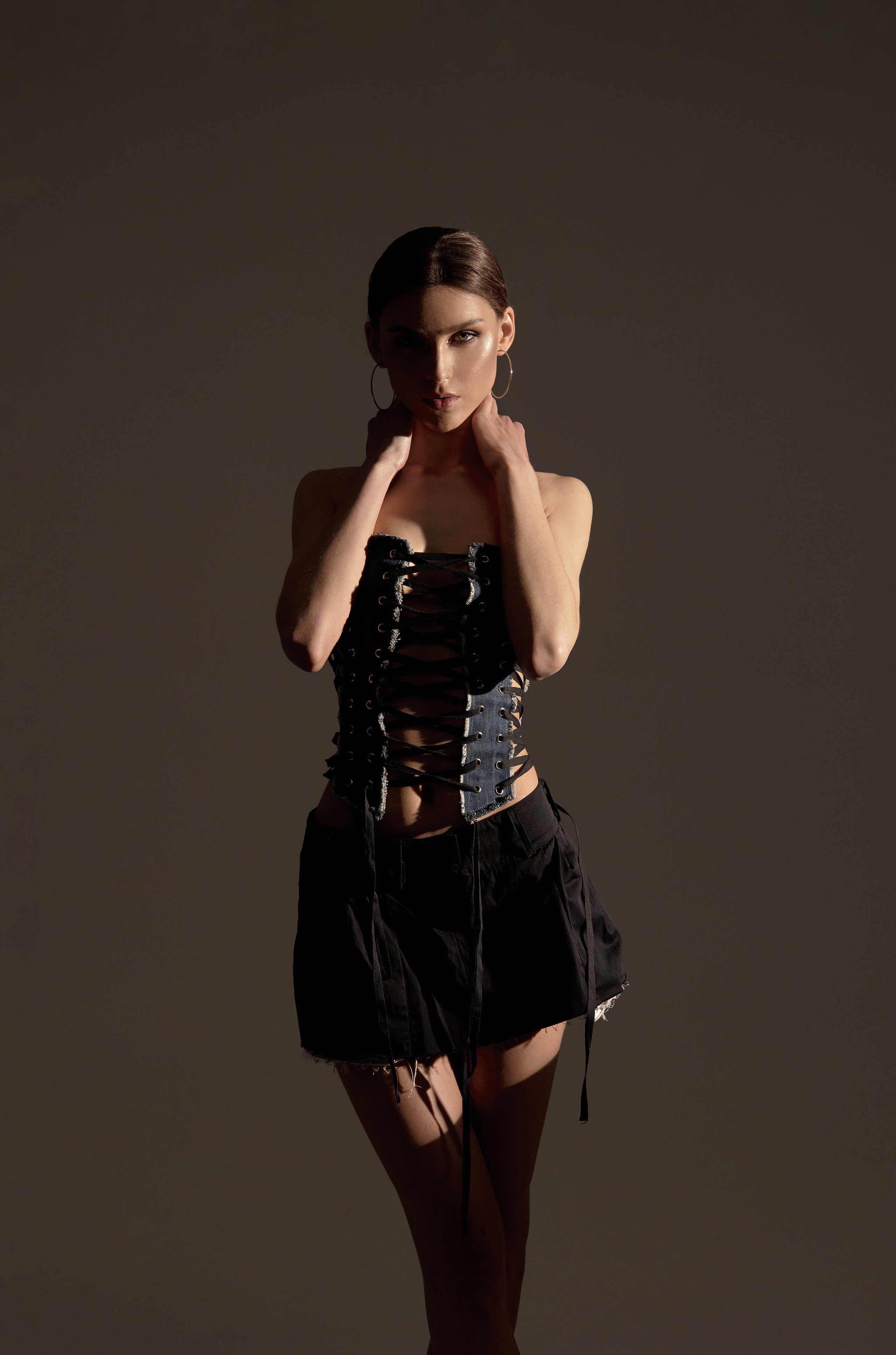 Девушка в джинсовом корсете смотрит исполобья в мини юбке профессиональная фотосессия 