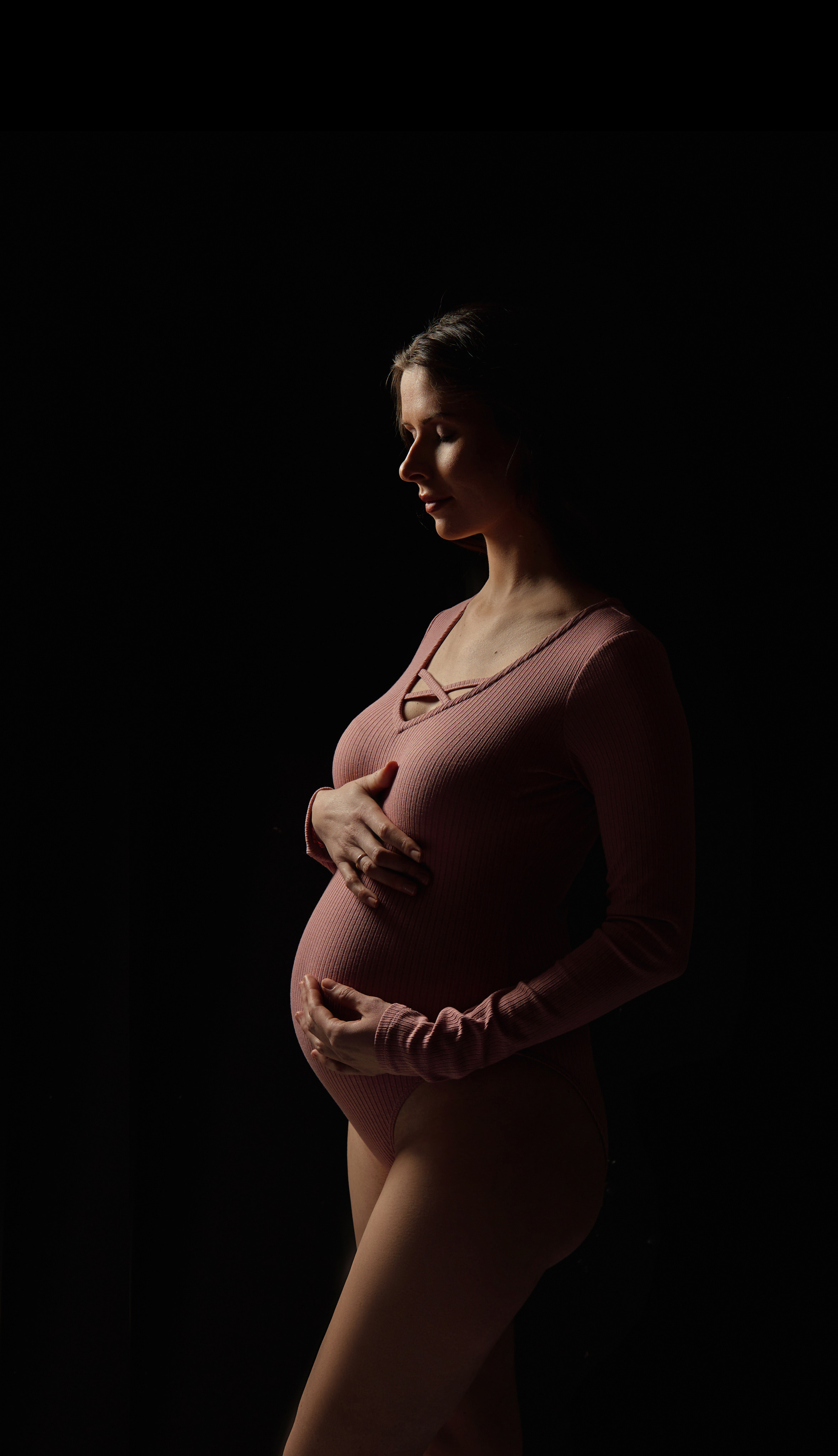 силуэт беременность девушка в бежевом боди с животом на черном фоне в фотостудии Домодедово