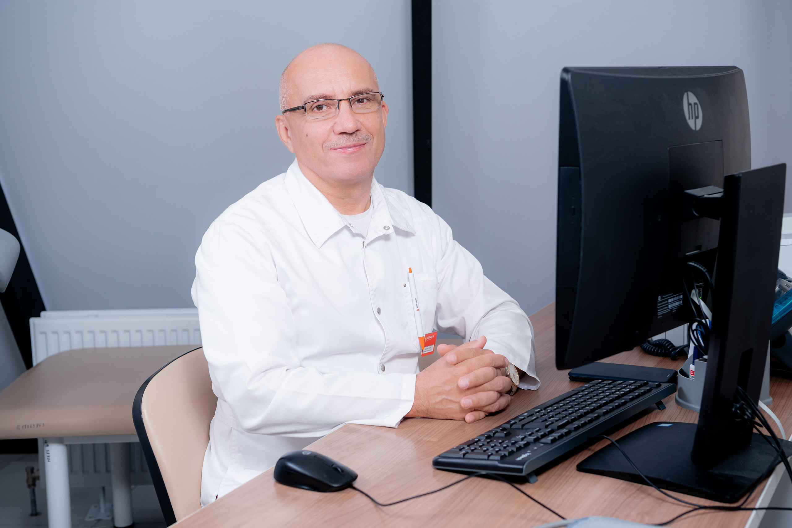 Профессиональный портрет врача-репродуктолога в белом халате в кабинете клиники ЭКО Волгограда.