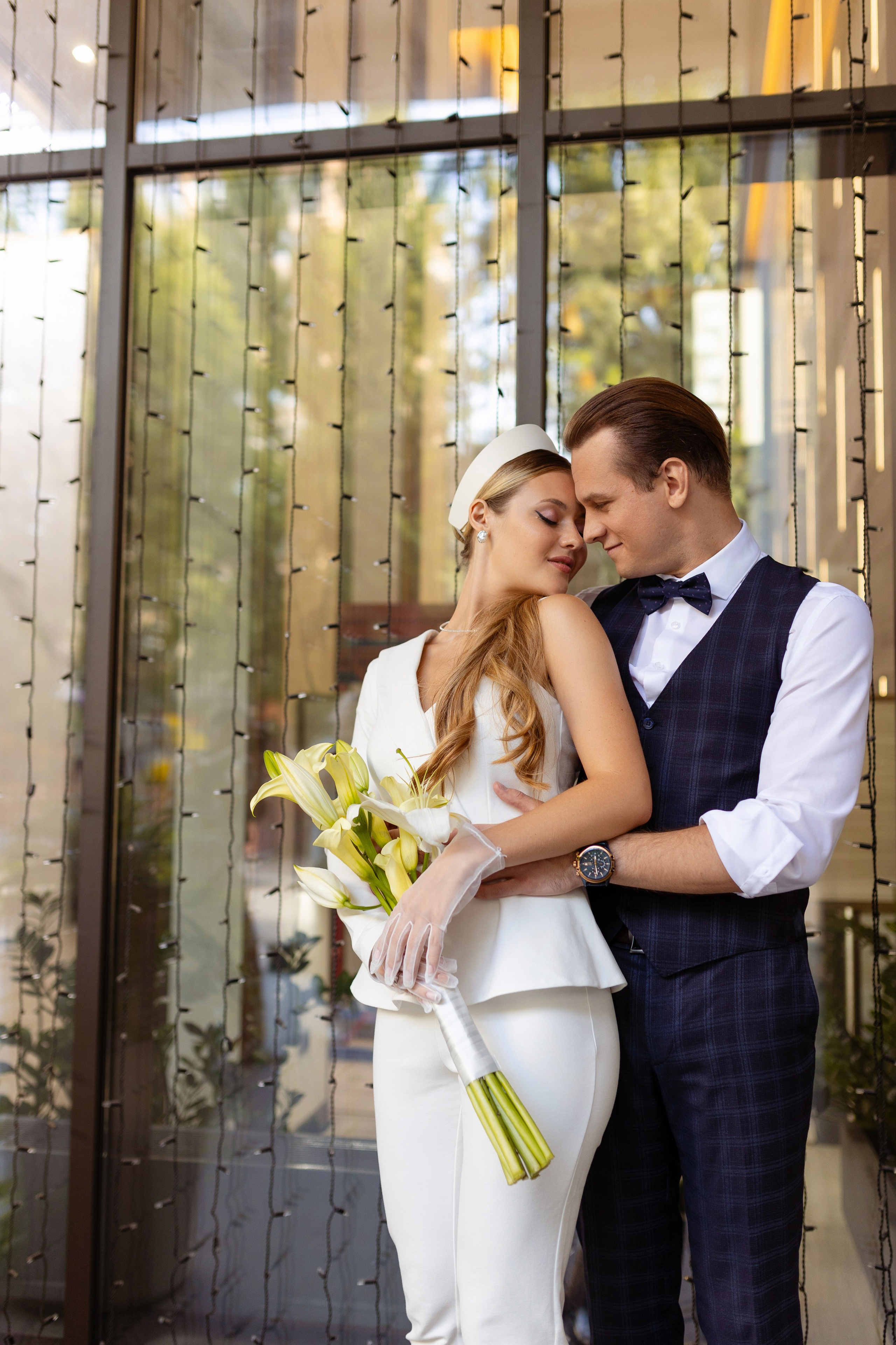 Молодые на фоне стеклянной стены.