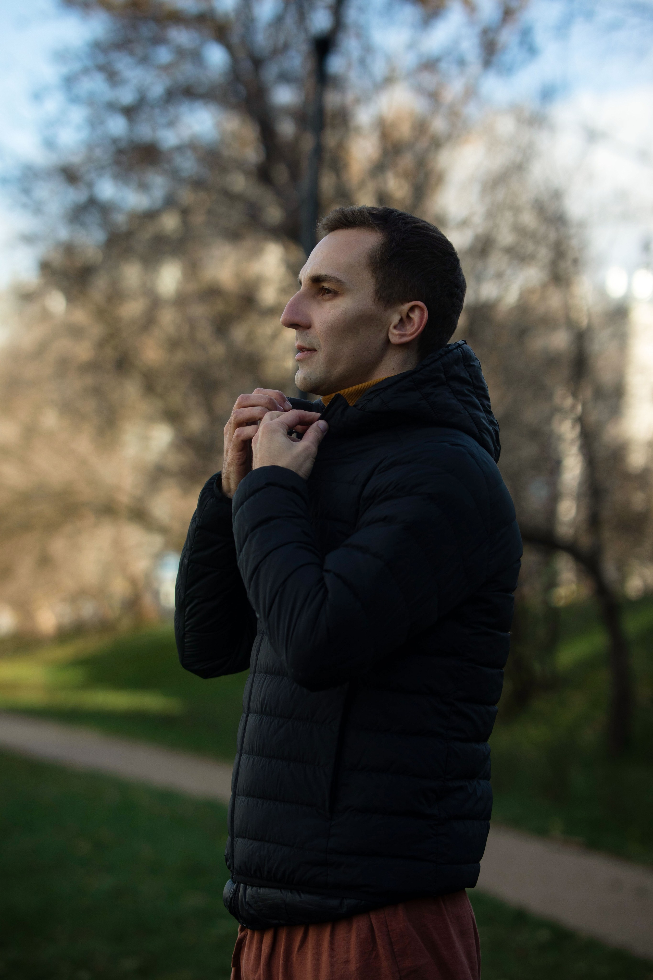 мужчина поправляет воротник куртки