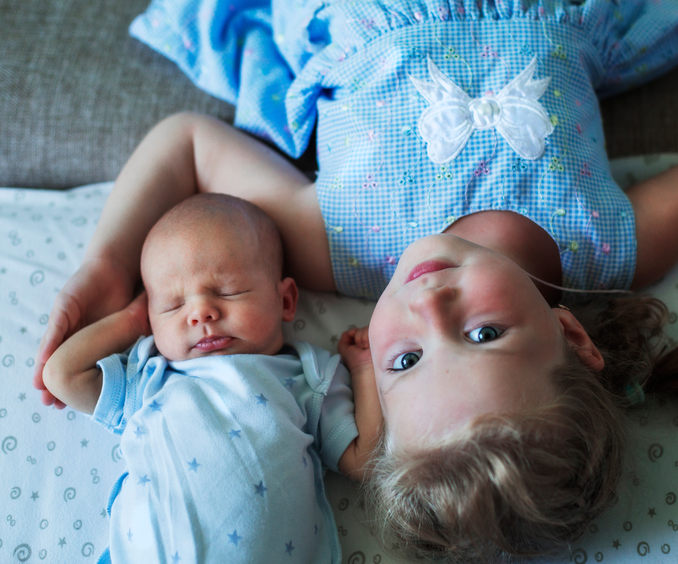 Новорожденный Роман спит под защитой своей старшей сестры.