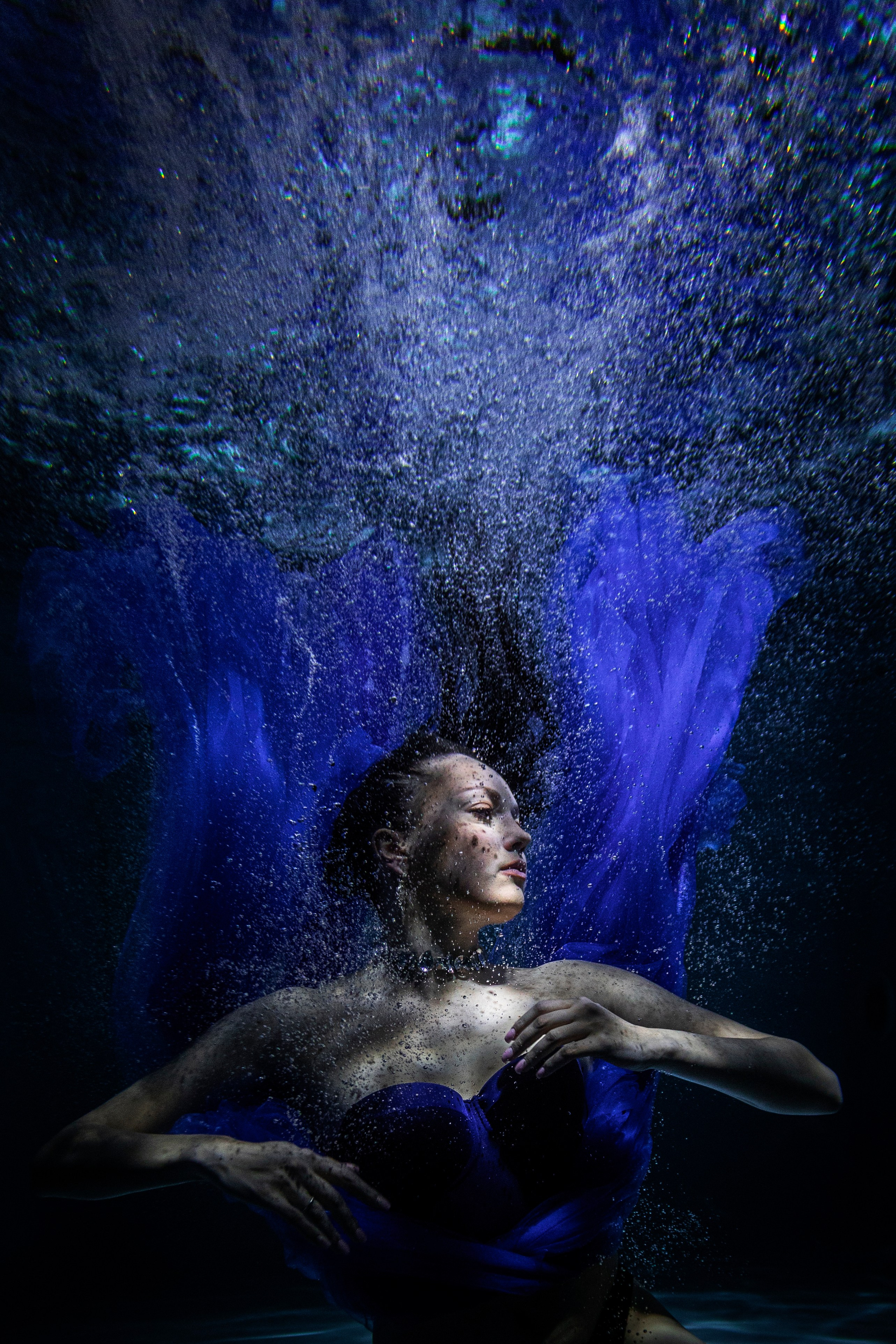 Девушка под водой в фотостудии Nemo, синее платье развевается, креативная подводная съемка