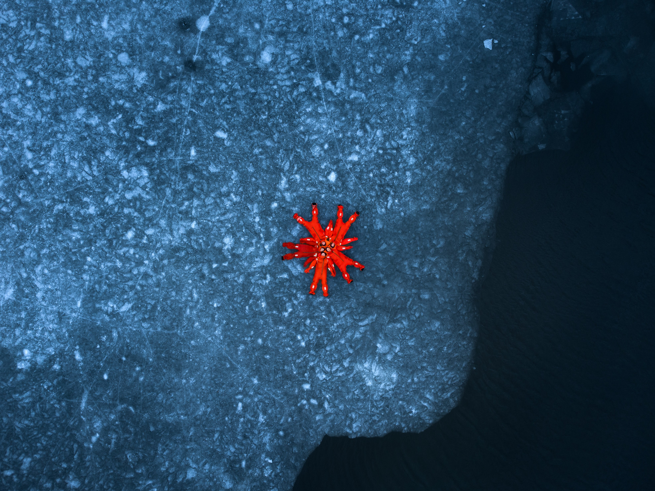 Люди купаются среди льдин, в спасательных оранжевых термо костюмах, айс флоатинг Ярославль