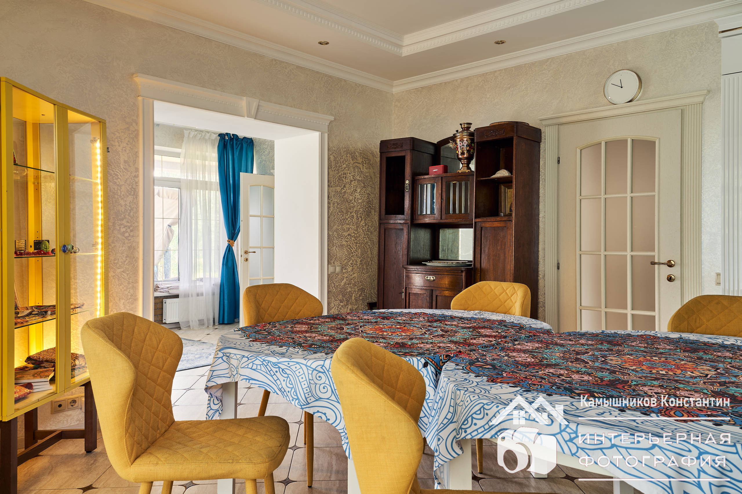 Интерьерное фото обеденного стола, стульев, кухонных шкафов и дверей в другие помещения