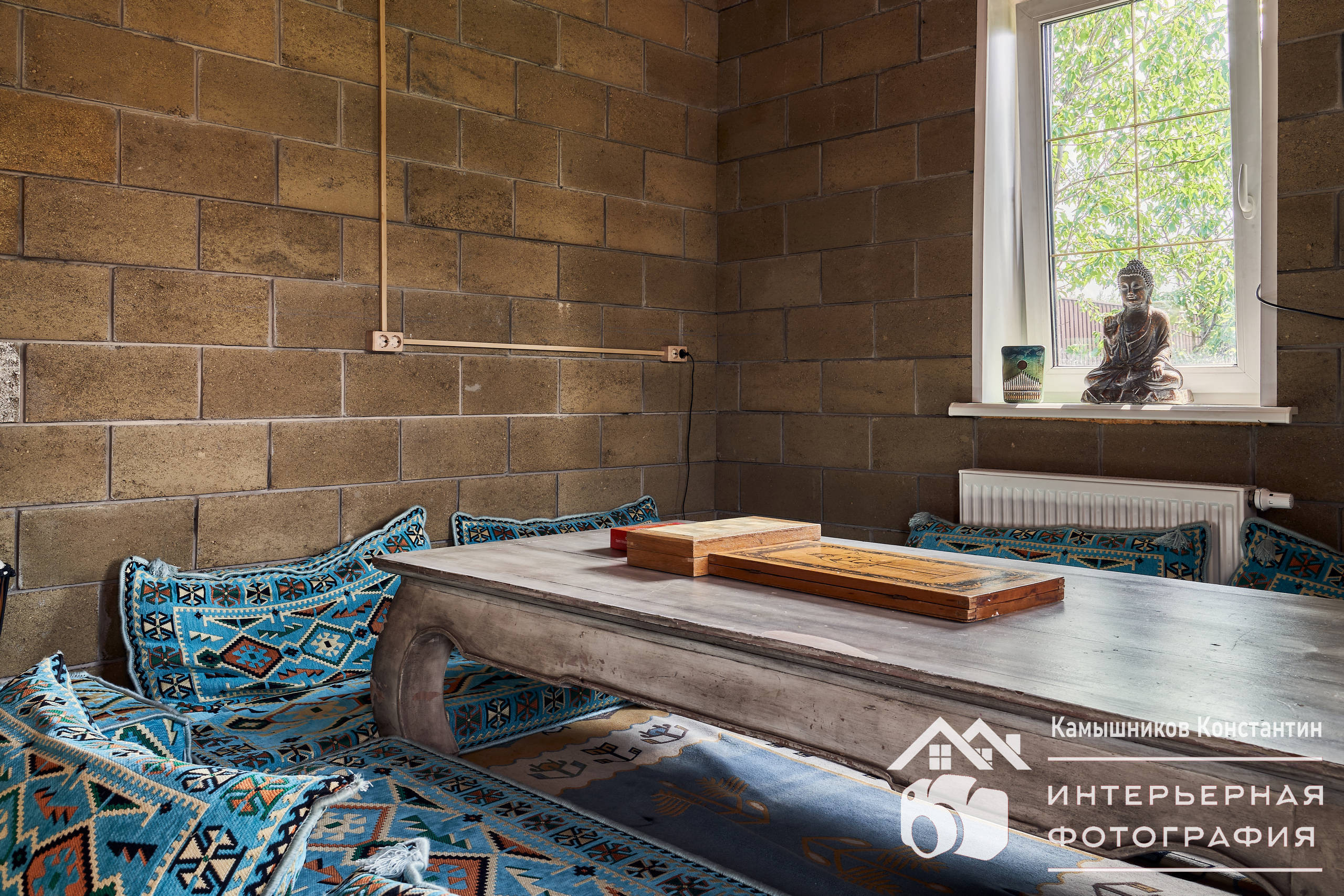 Интерьерная съемка в бане со столом и подушками в предбаннике в загородном доме в Московской области