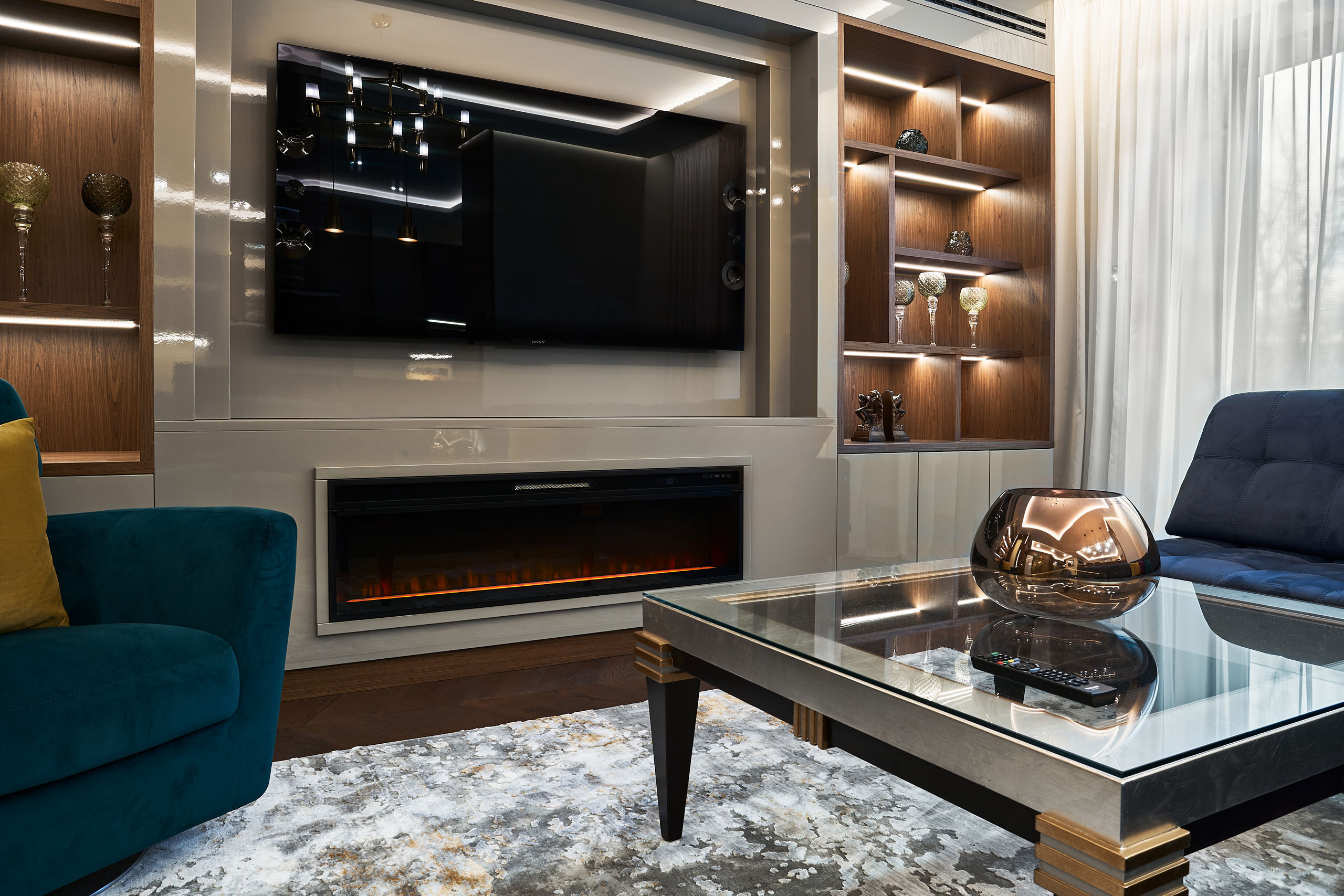 Интерьерная фотосъемка гостиной в апартаментах с телевизором и камином