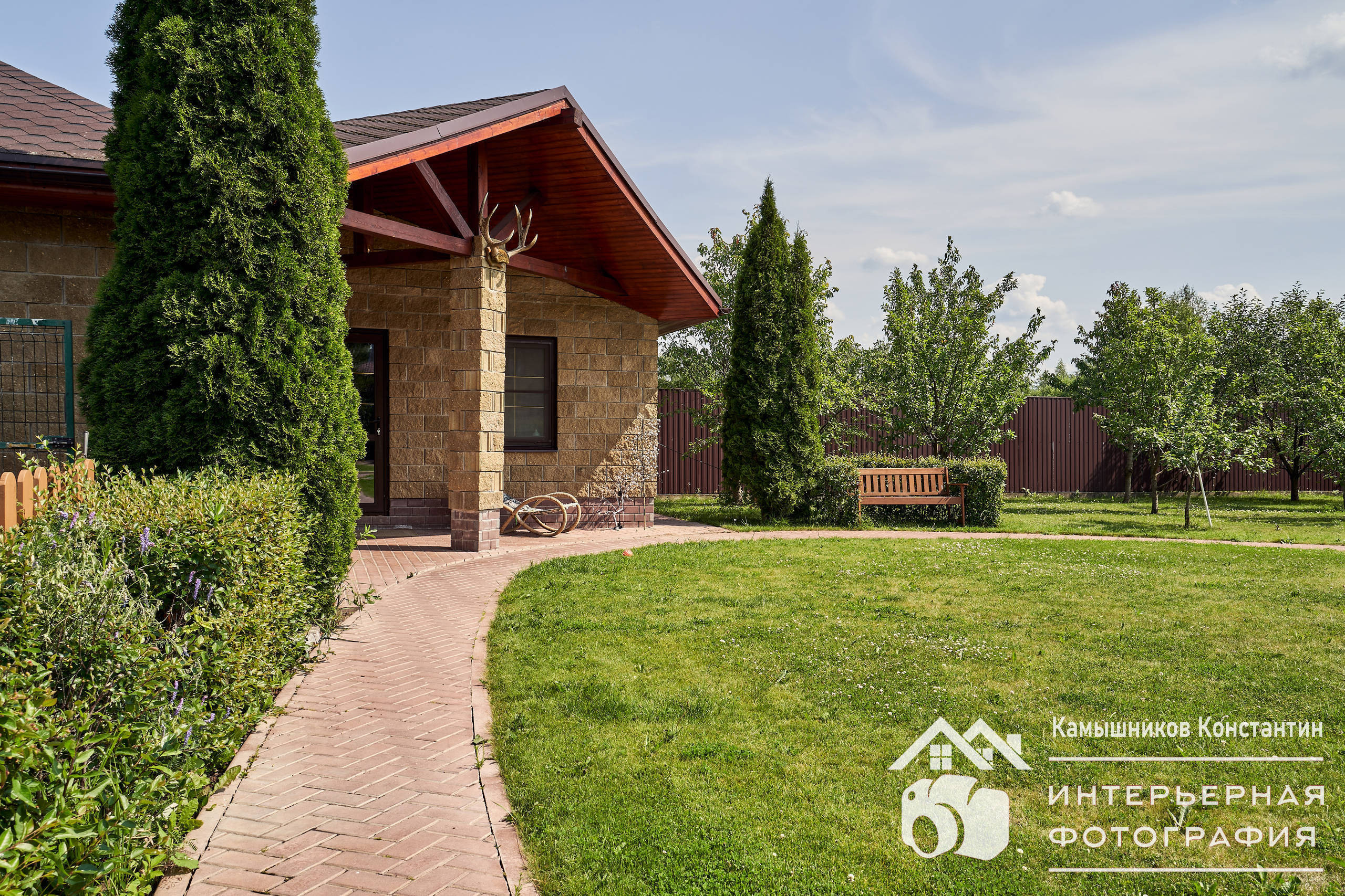 Архитектурная съемка с красивой дорожкой, скамейкой, креслом-качалкой на участке загородного дома в Московской области