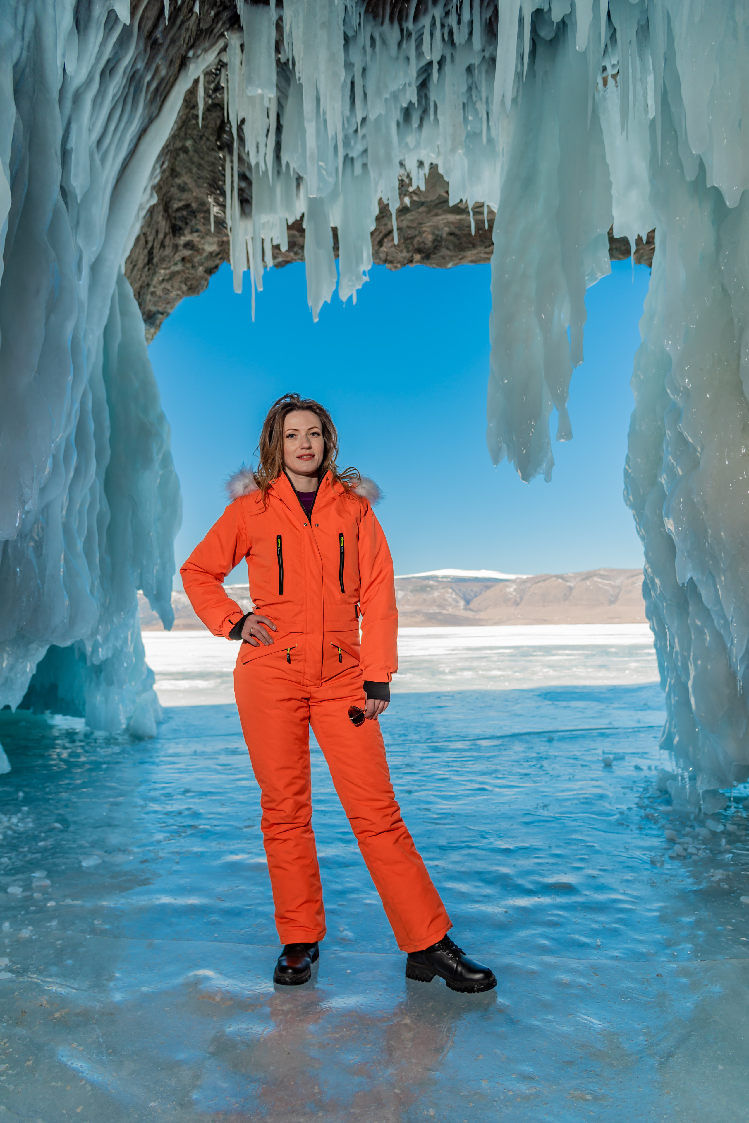 Гроты и сосульки на байкале. Зимний оранжевый комбинезон