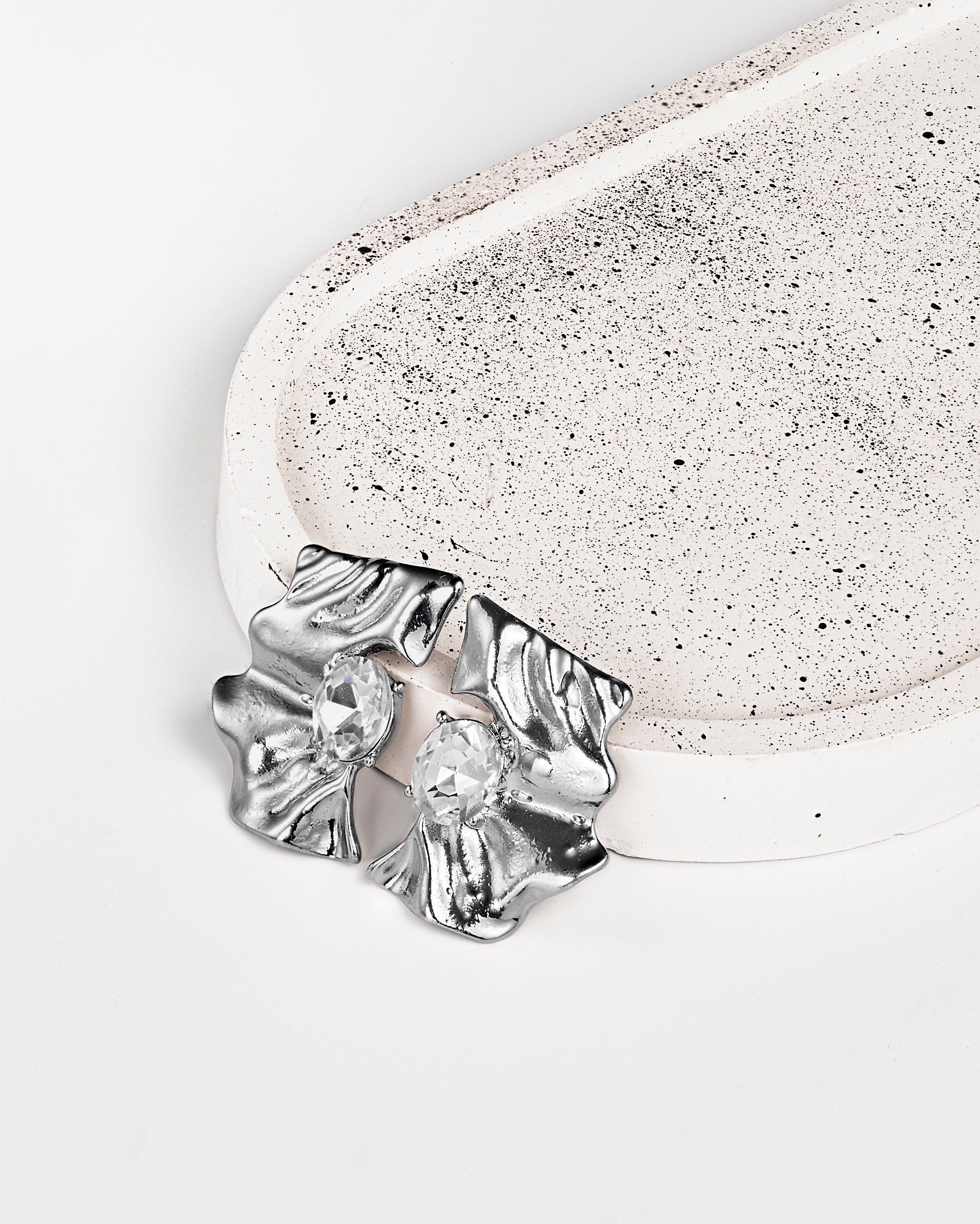 Имиджевое фото серебряных серег с минимальной композицией