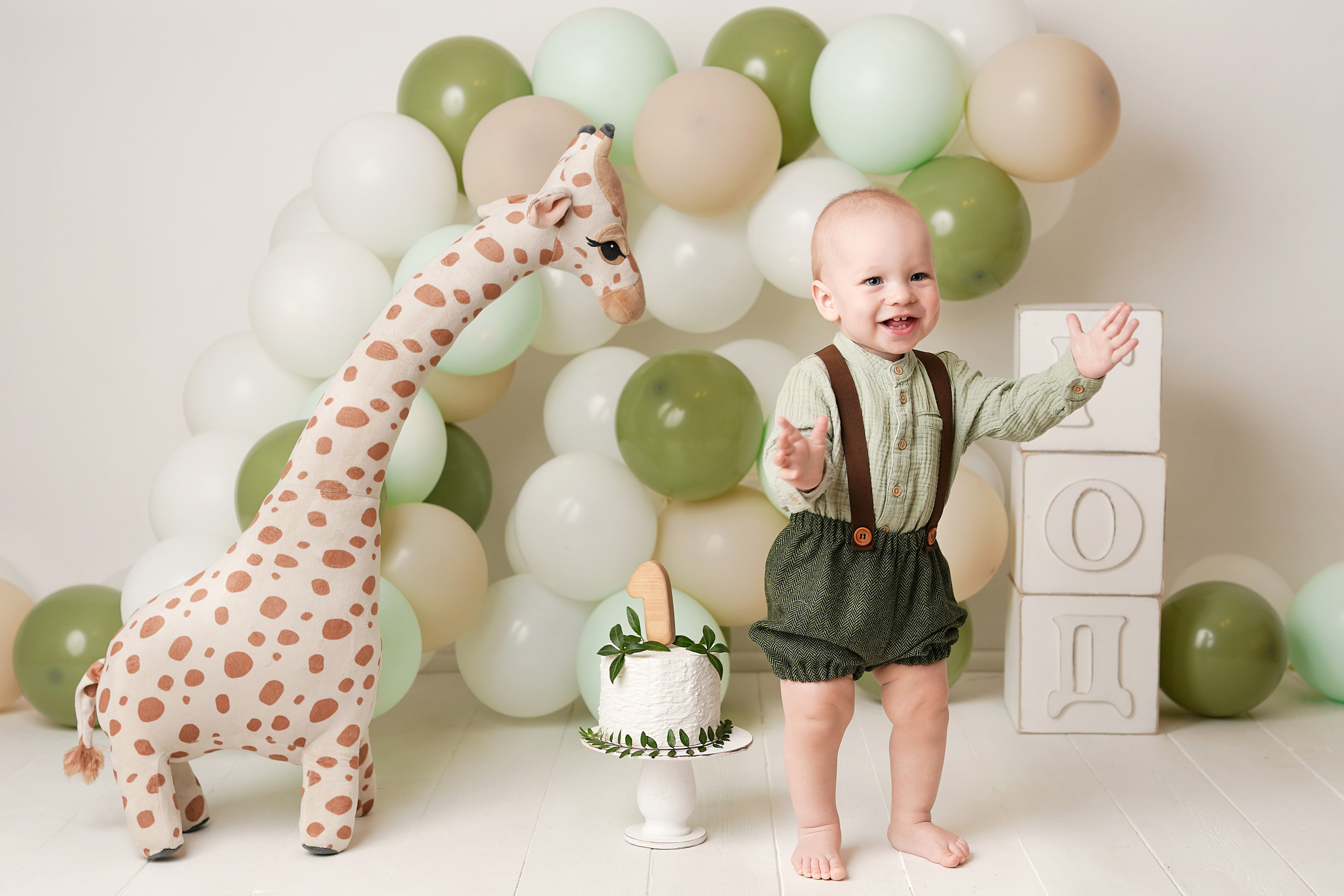 Для детской фотосессию  фотограф подготовила шарики и торт, сфотографировала Пашу с жирафом.