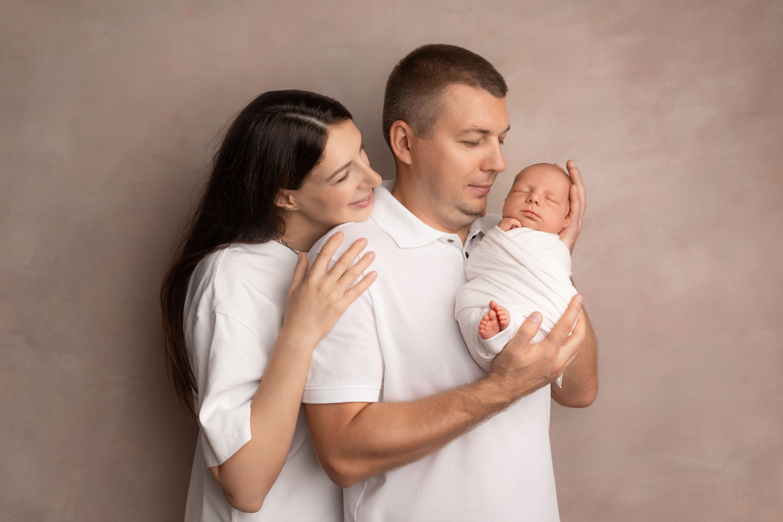 мама и папа держат в руках  новорожденного малыша