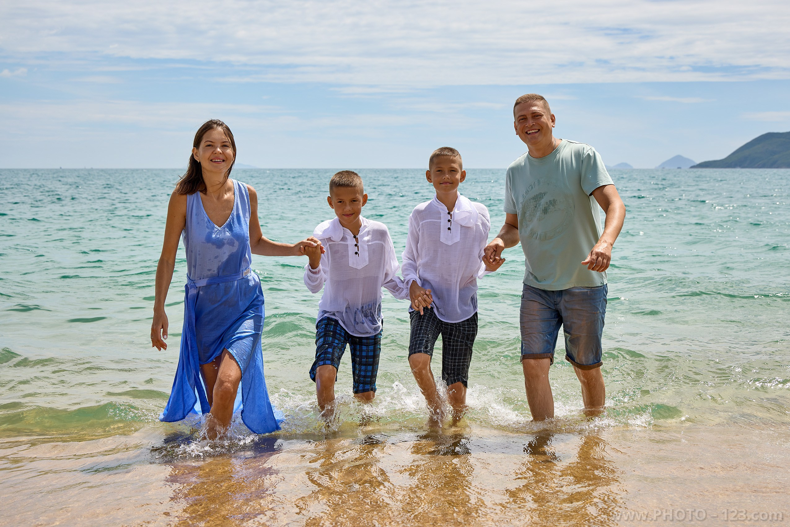 Parents and twin sons walking in shallow ocean water | Captured by expert with 20+ years experience