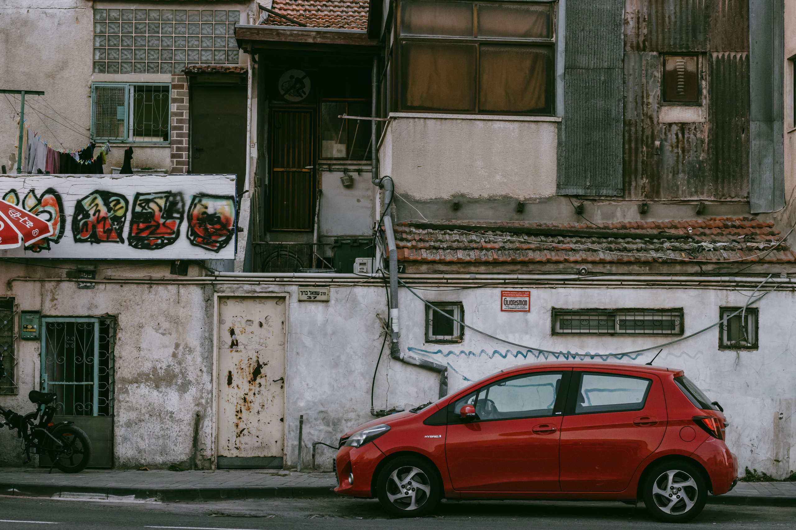 Старые иерусалимские дома, лачуги, рядом красная машина