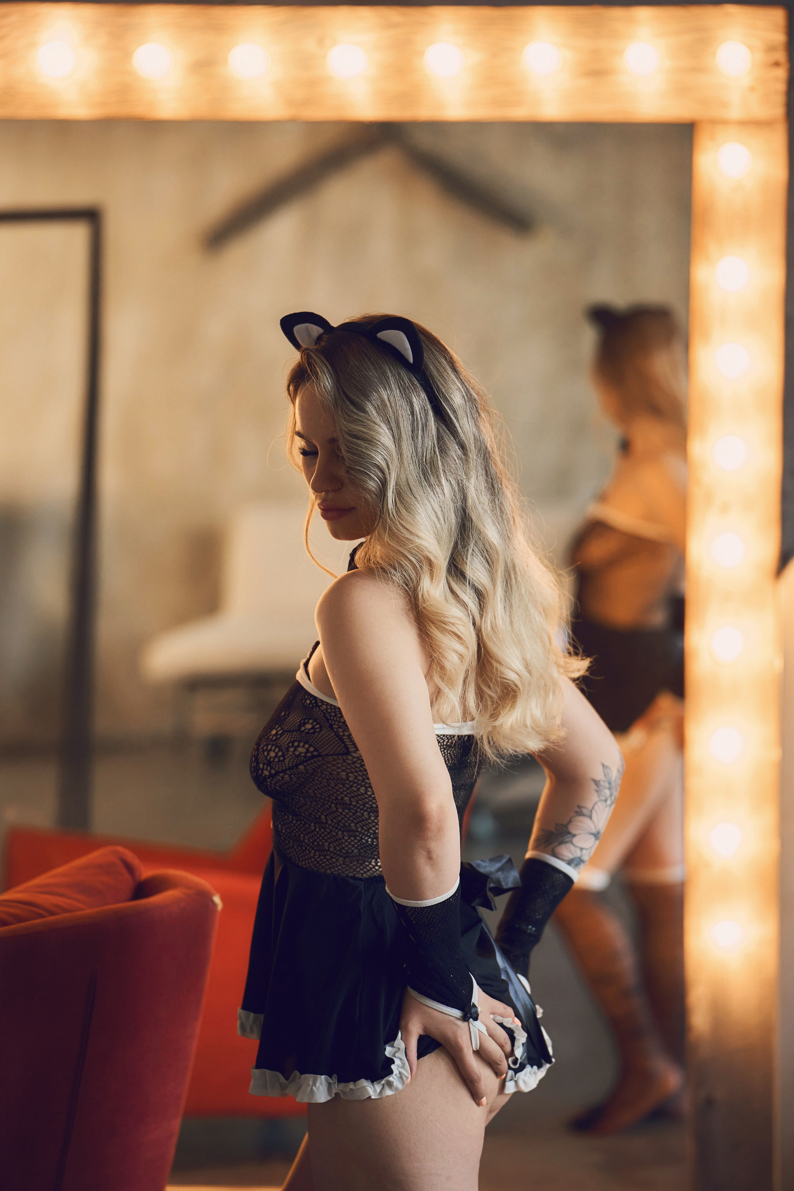 девушка у ростового зеркала в гримёрной в черном нижнем белье и кошачьих ушках