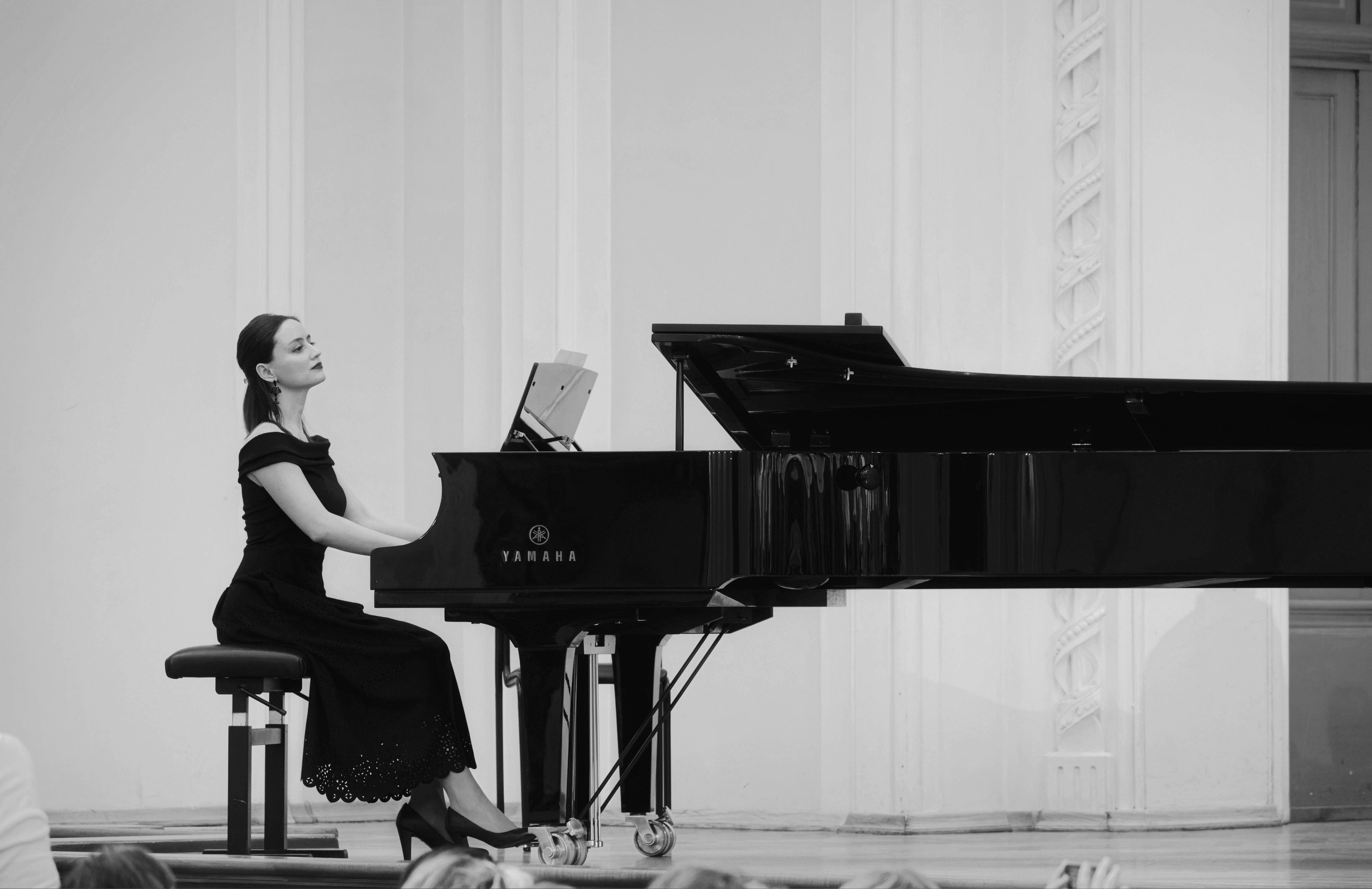 Пианистка в черном платье играет на концертном рояле Yamaha - черно-белая художественная фотография, классическая музыка, элегантный белый зал
