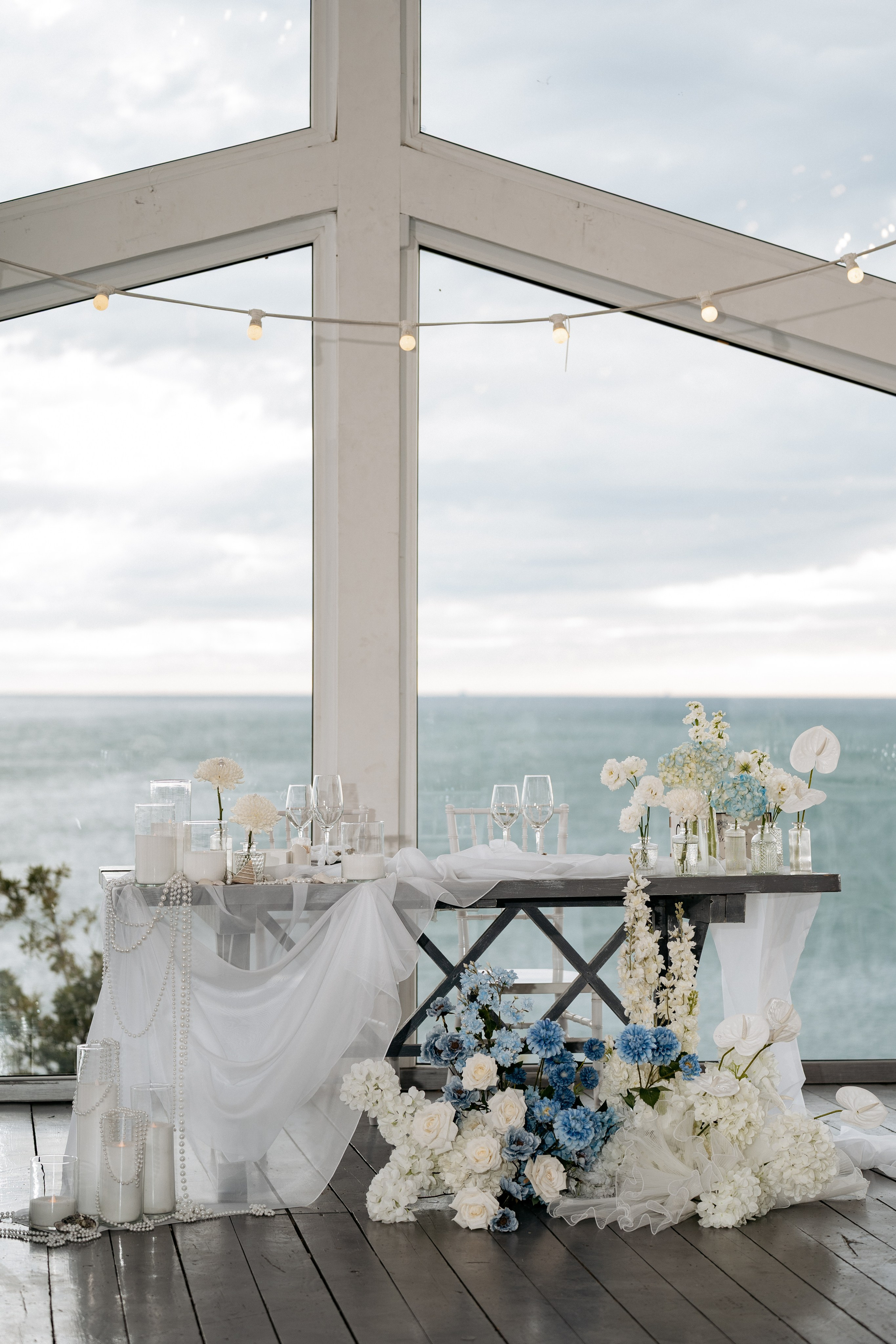 Фотограф в Геленджике снимает детали оформления банкета в ресторане на берегу.