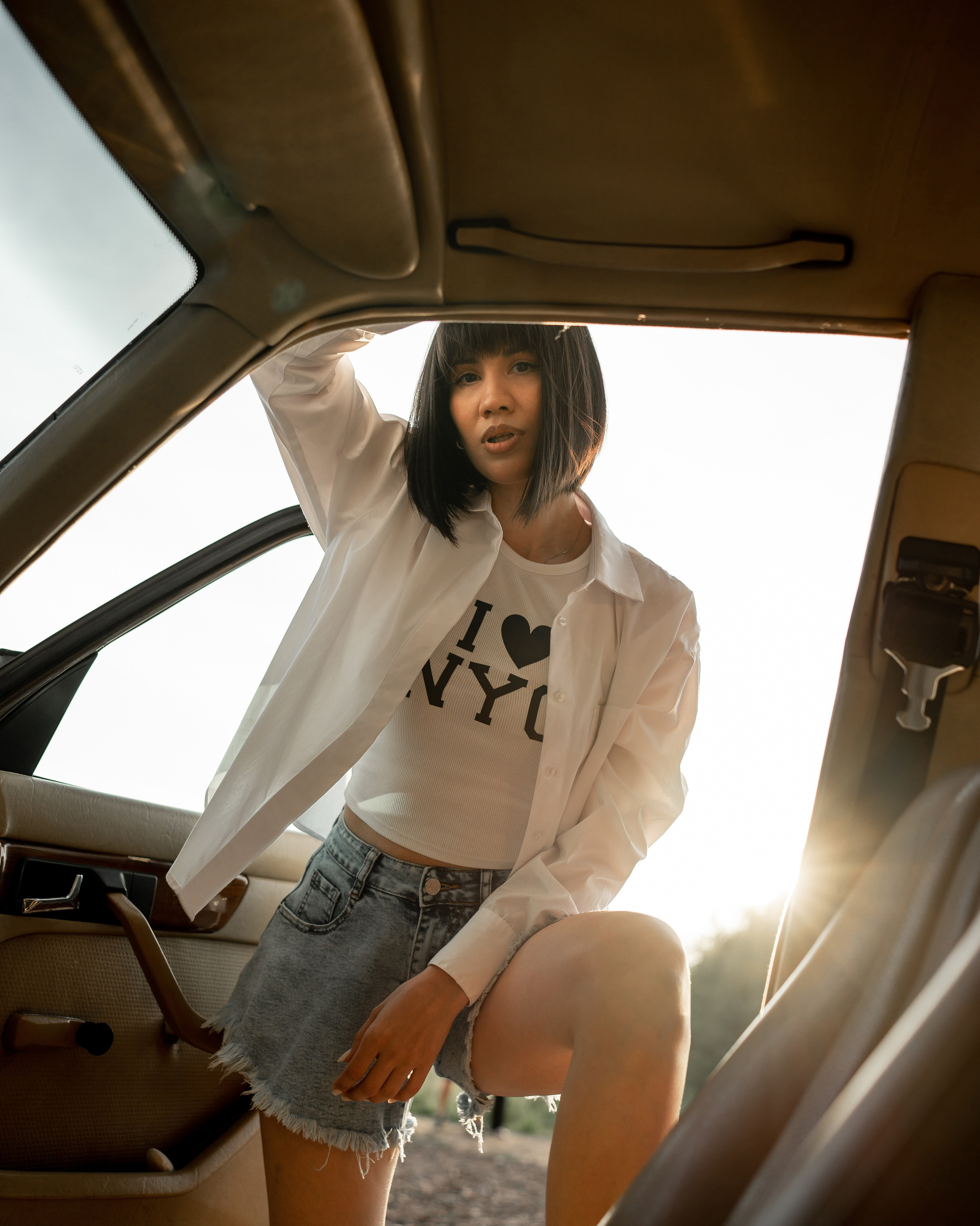 Девушка у автомобиля на закате