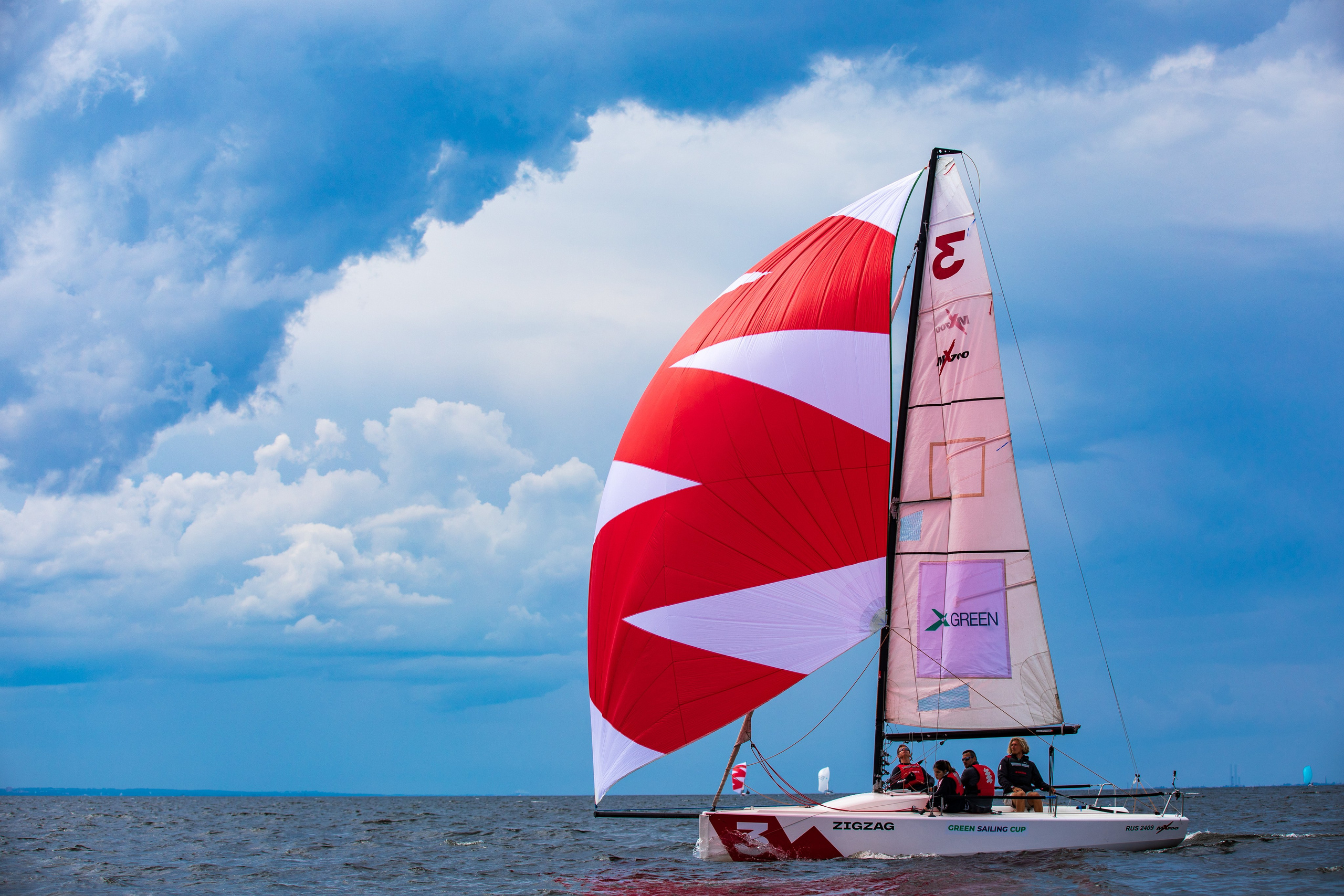 Спортивная парусная яхта на фоне красивых облаков.