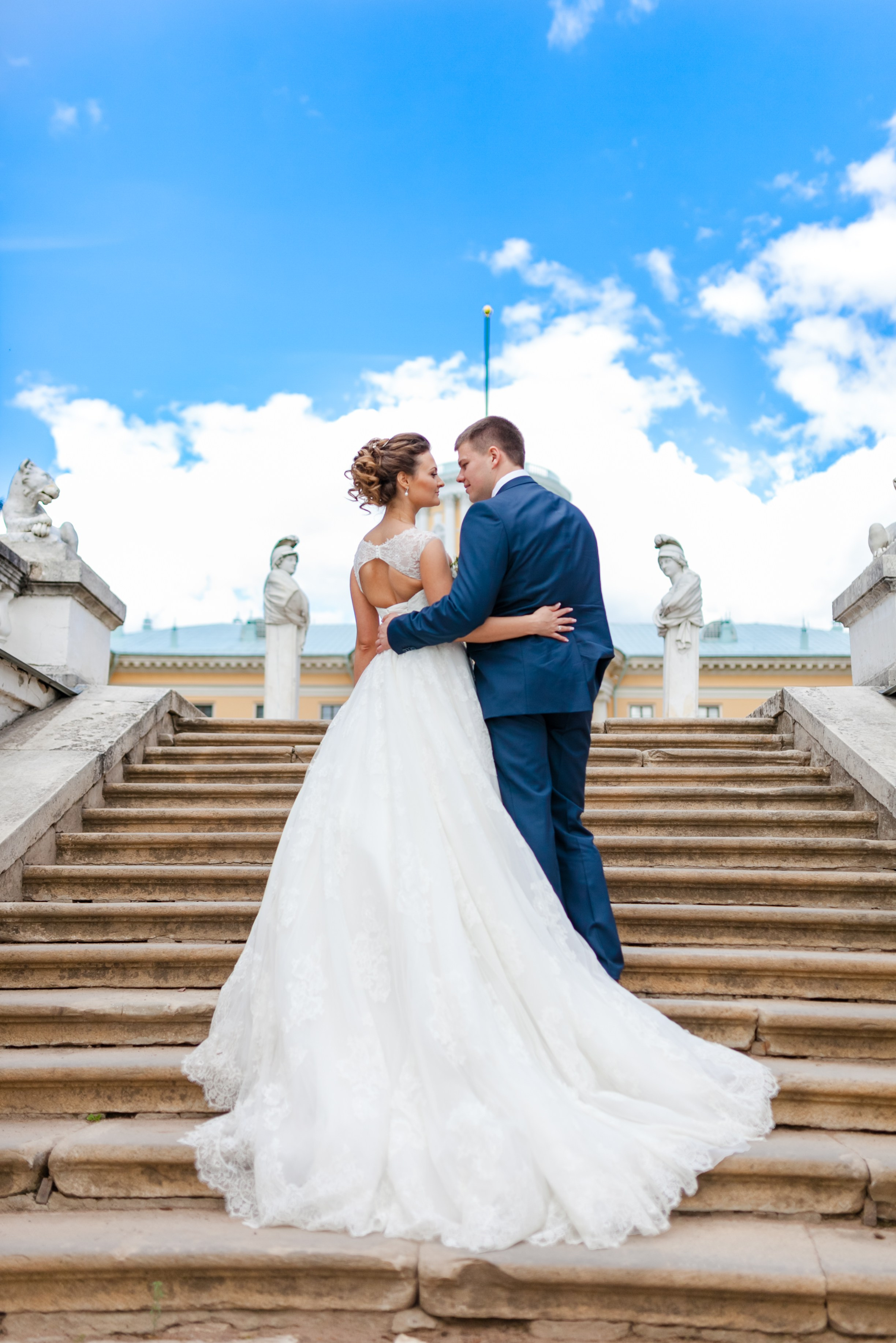 Красивая пара молодожен стоит на большой лестнице