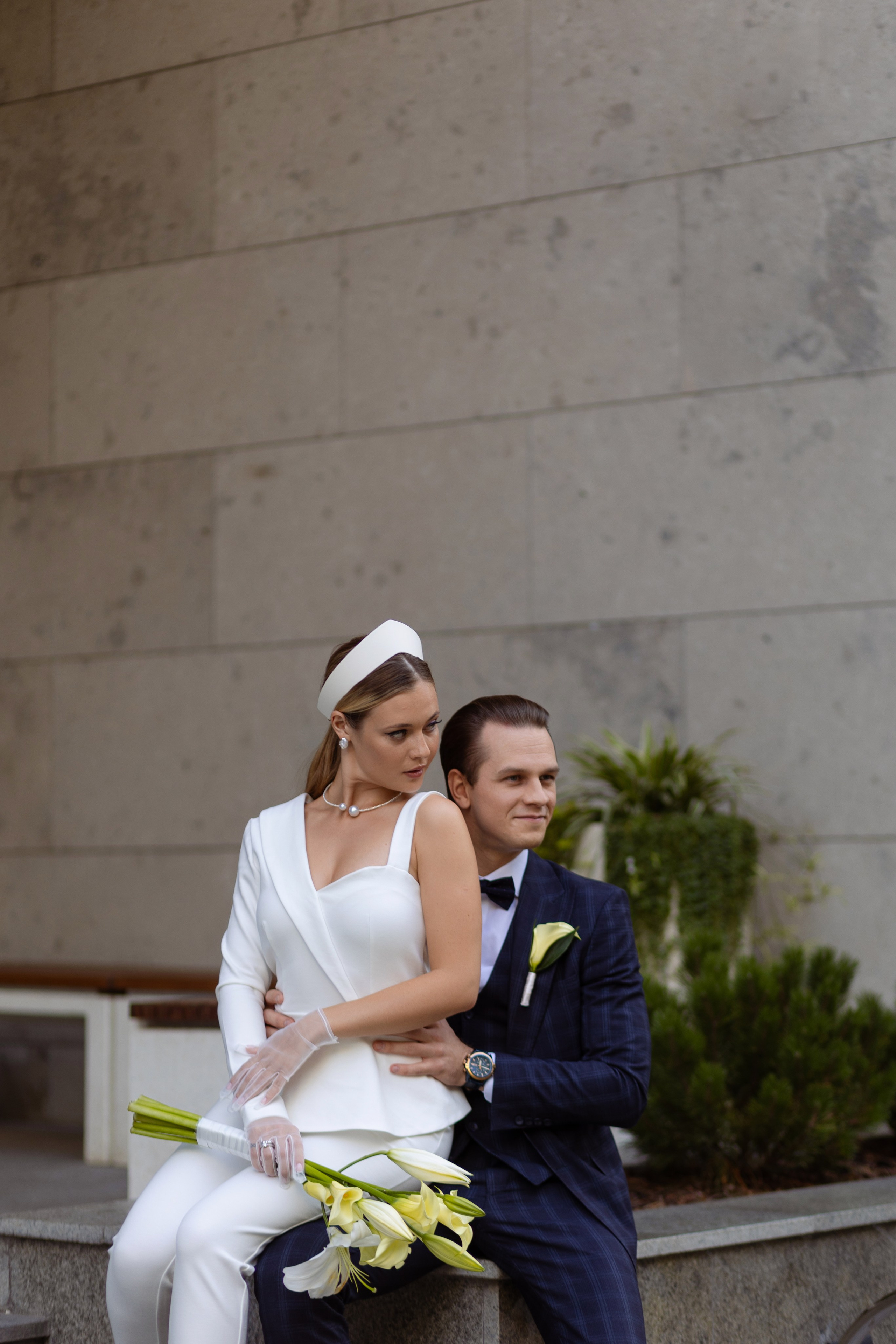 Жених обнимает за талию свою невесту.