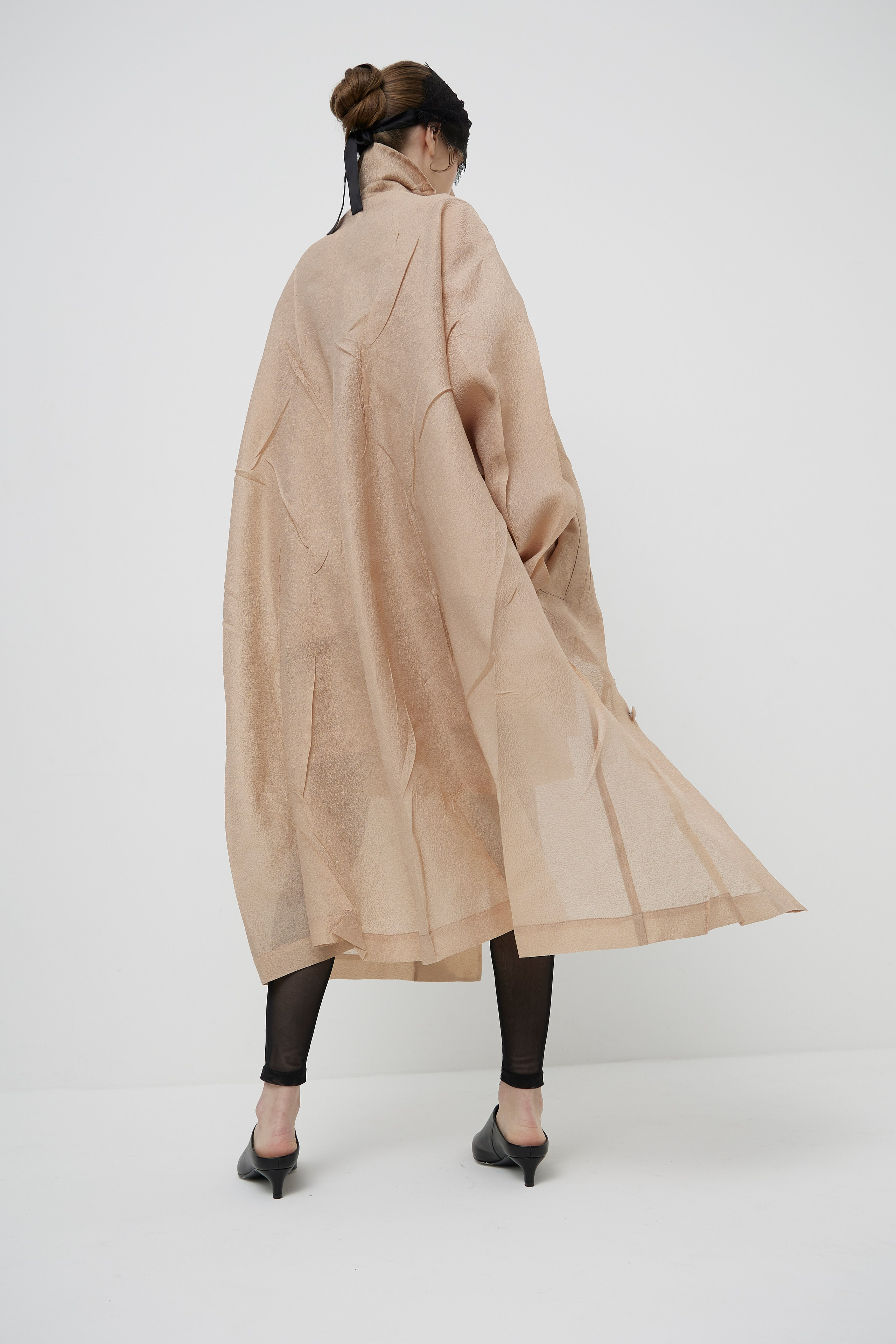 Back view fashion lookbook image of model wearing flowing designer coat photographed for fashion brand ecommerce photography in Sydney