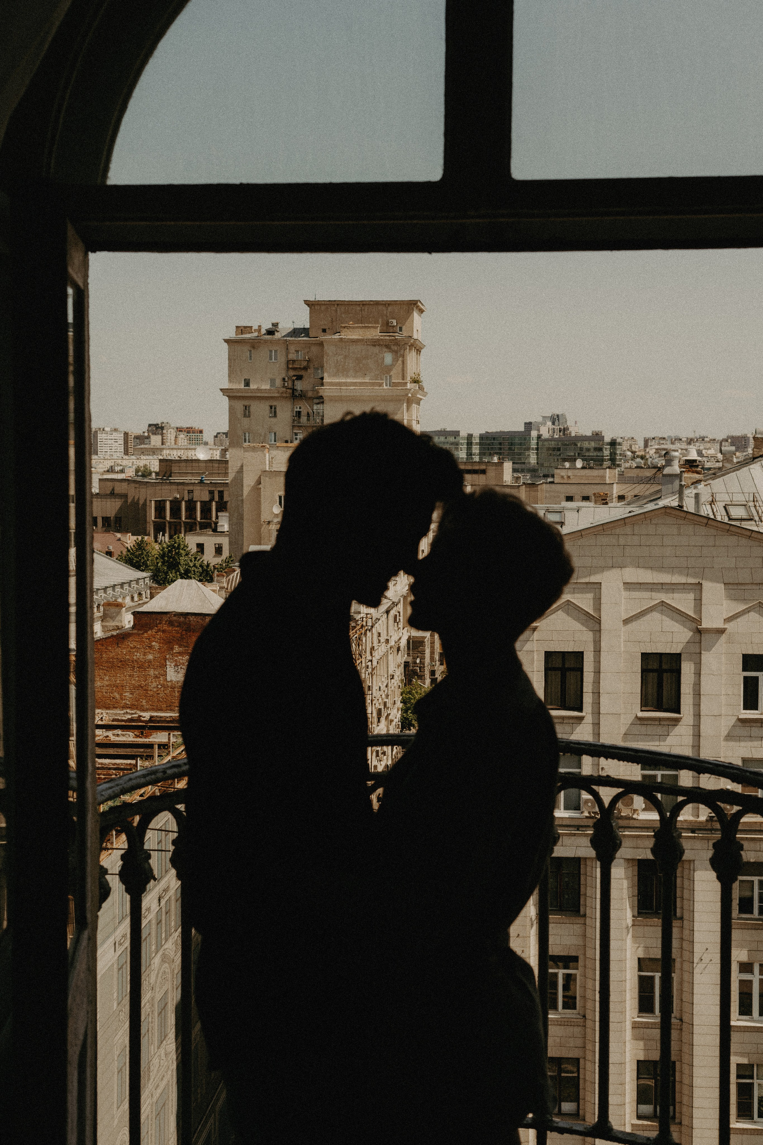 Силуэт влюбленной пары, которые стоят на балконе и вот вот поцелуются