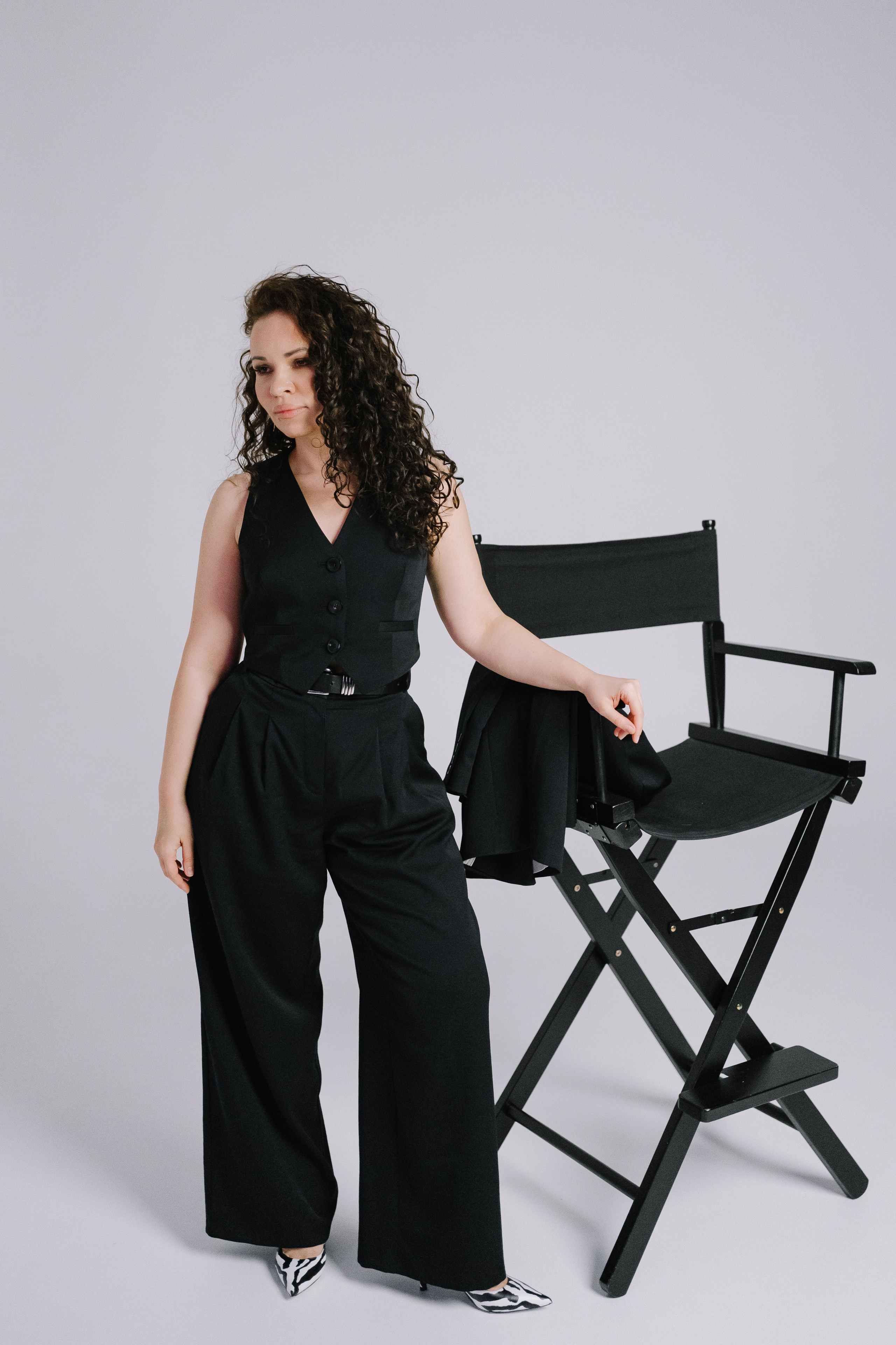 Девушка в черном костюме с распущенными волосами, создающий образ уверенности и стиля