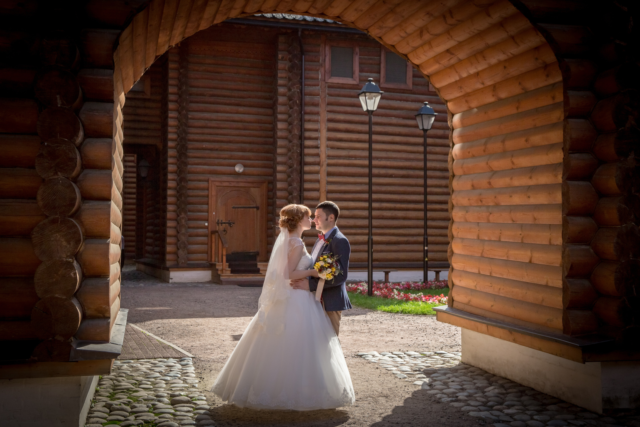 фотограф снимает жениха и невесту в арке дворца Алексея Михайловича в Царицыно